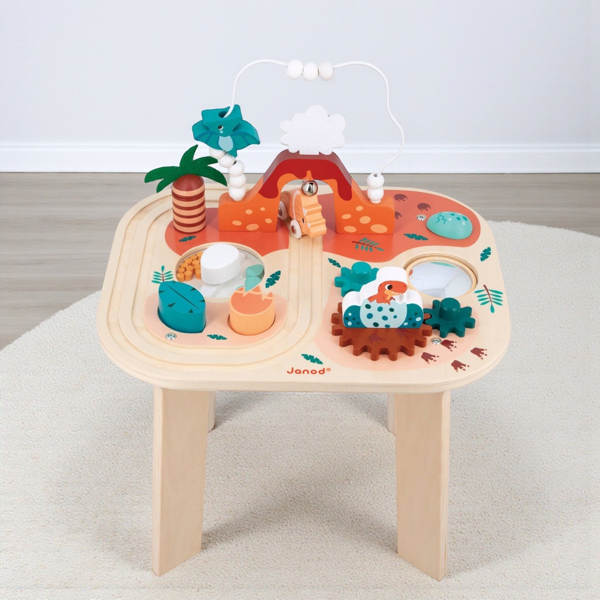 Wooden toy table with colorful animal figures and tracks on a light gray surface.