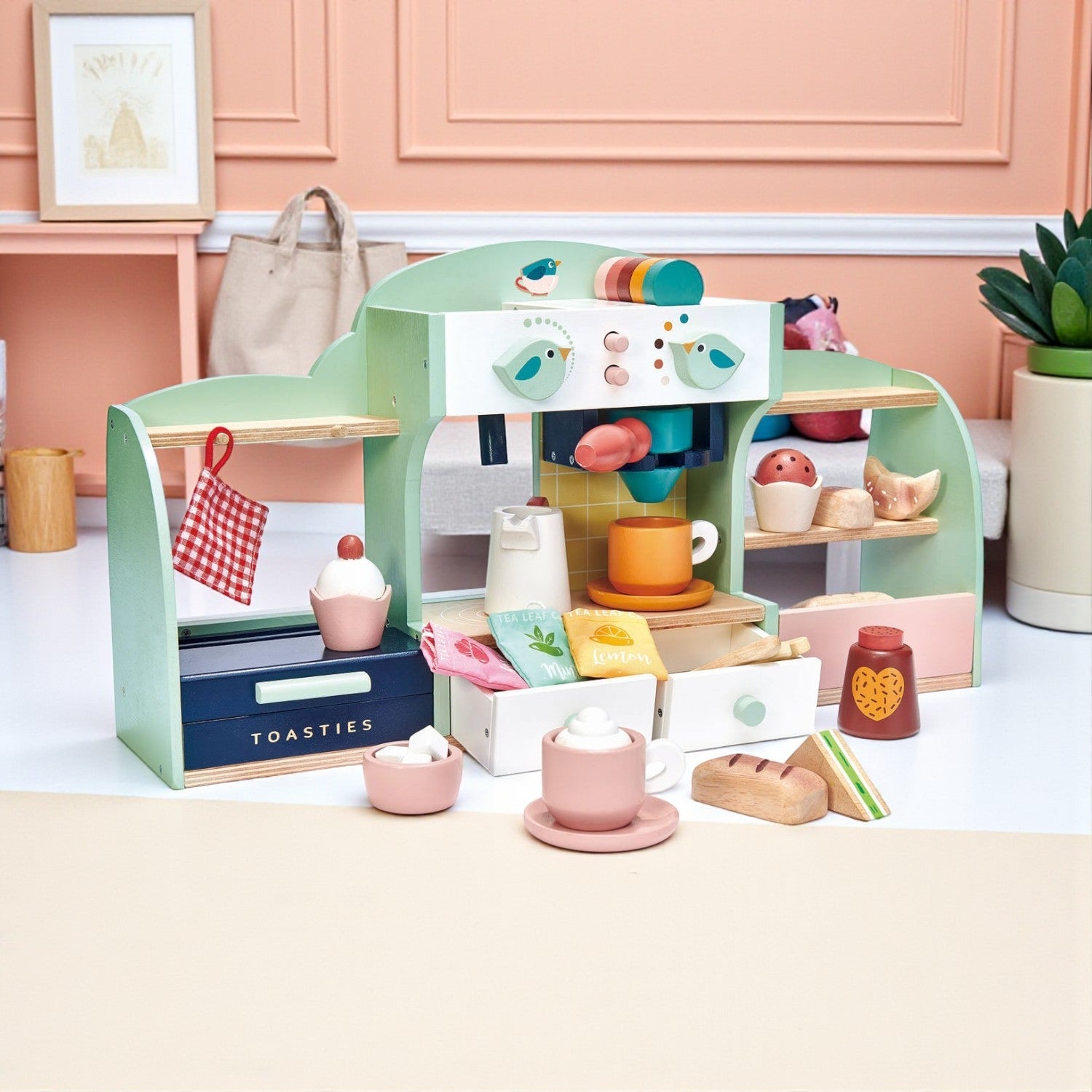 Children's toy kitchen set with various items on a white surface.