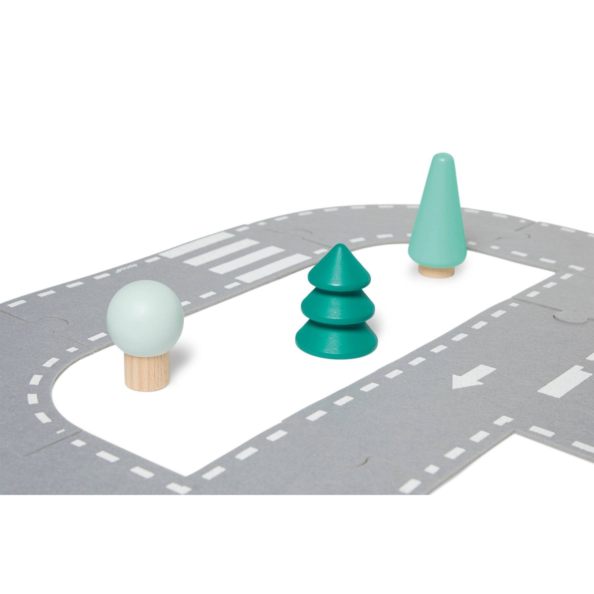 Wooden road toy set with green trees and traffic cones on a gray road surface.