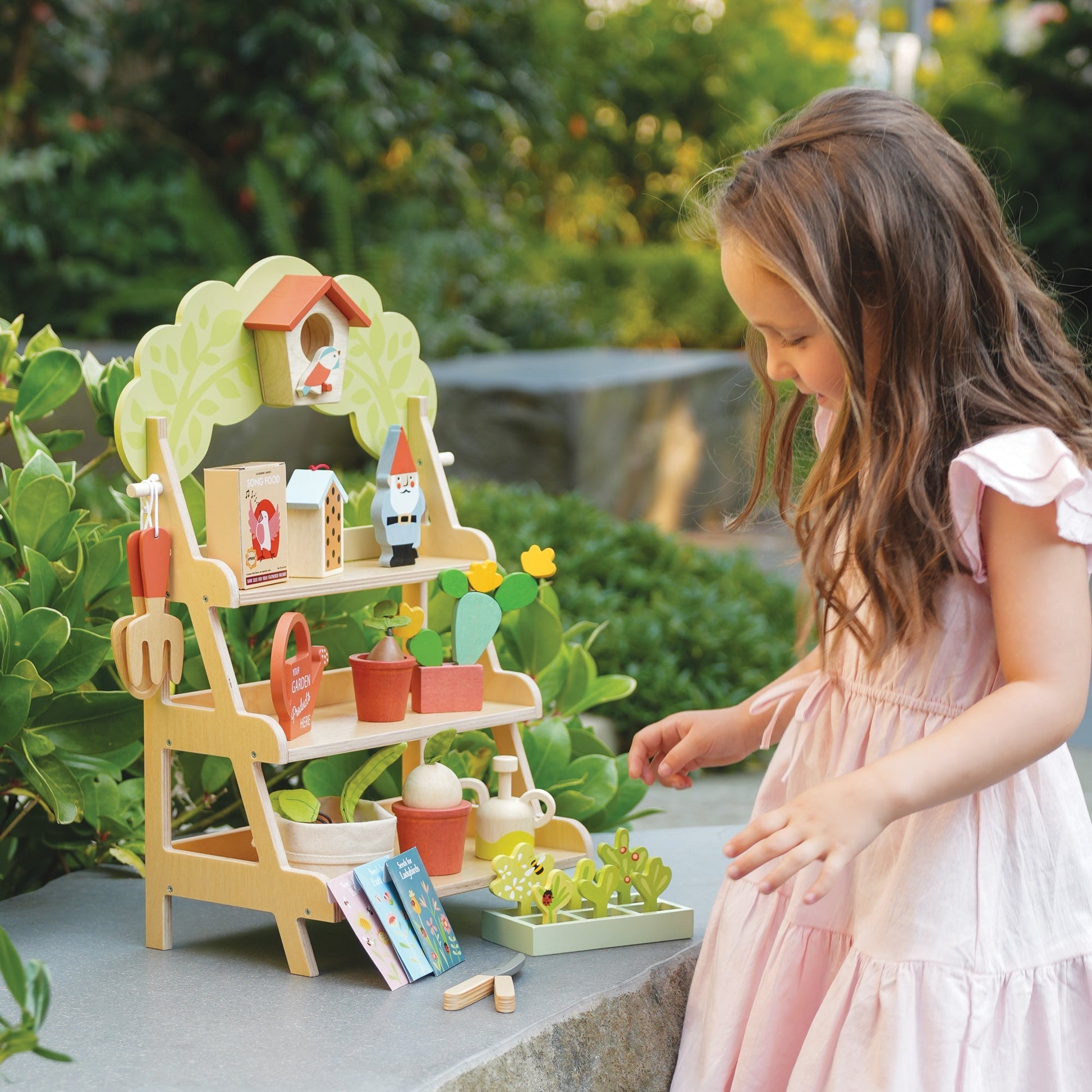 Child playing with a toy garden set outdoors