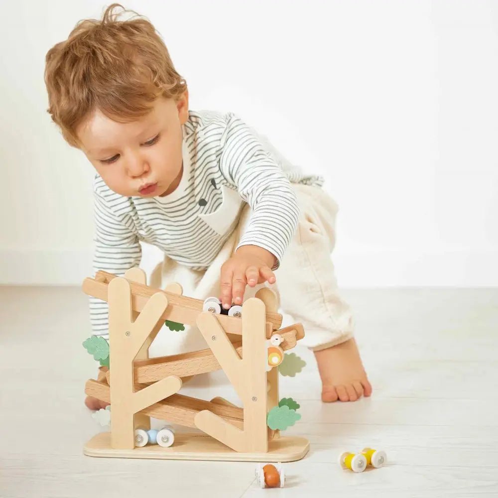 Child playing with a wooden toy on a light-colored floor.