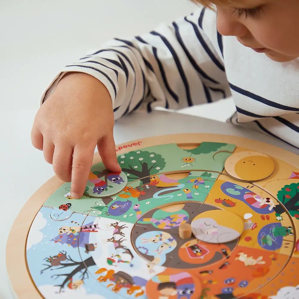 Child playing with a colorful circular puzzle on a white surface