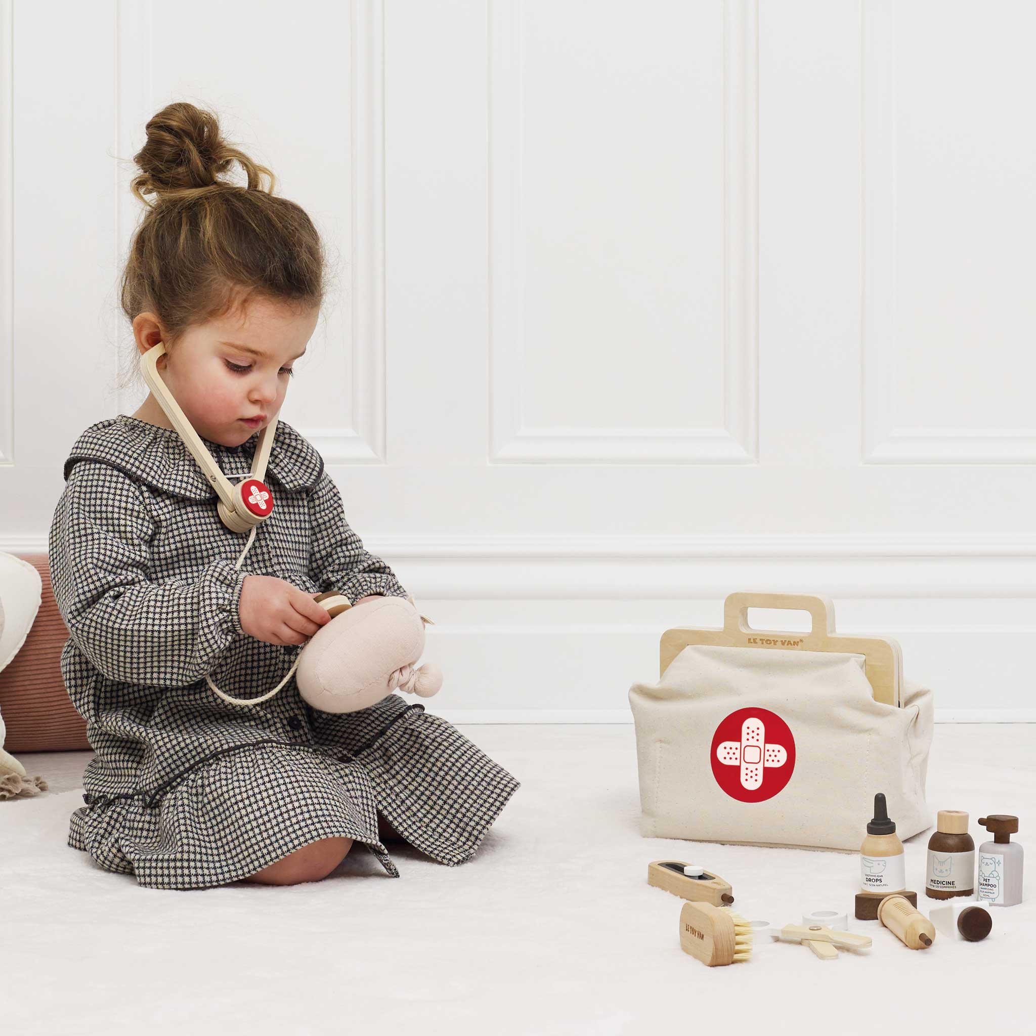 A girl playing with a vets set of toys