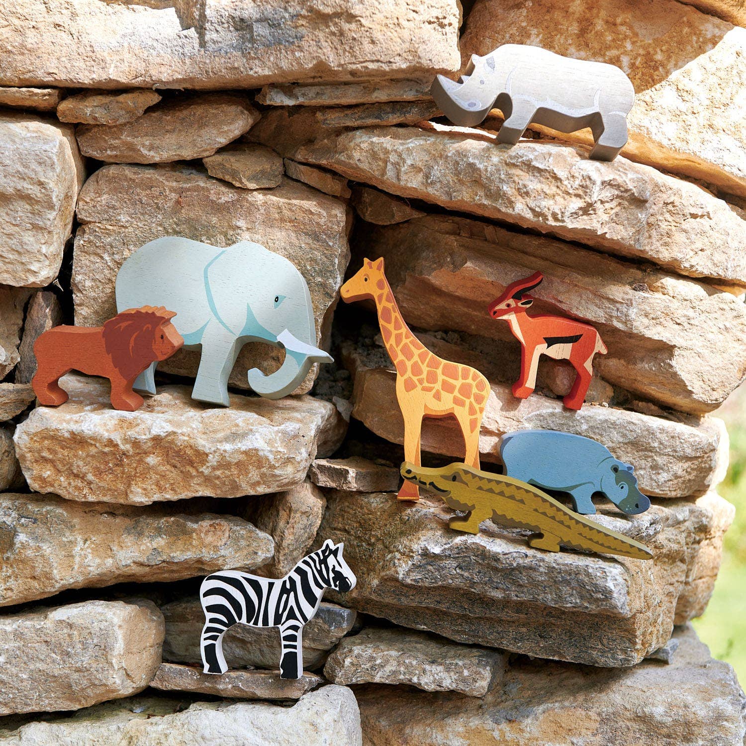 Wooden animal toys on a stone wall