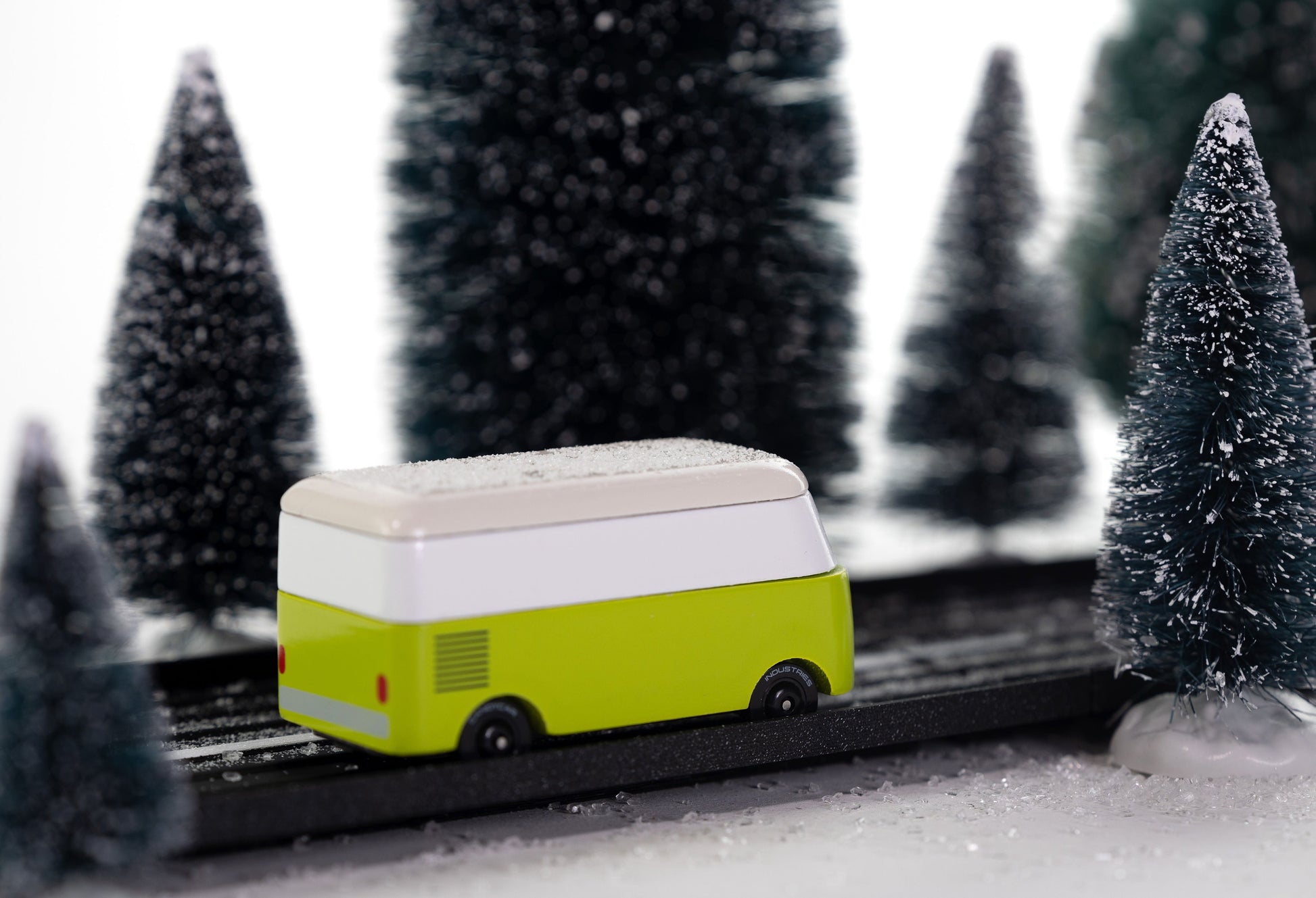 Toy van on a track with snow-covered trees in the background