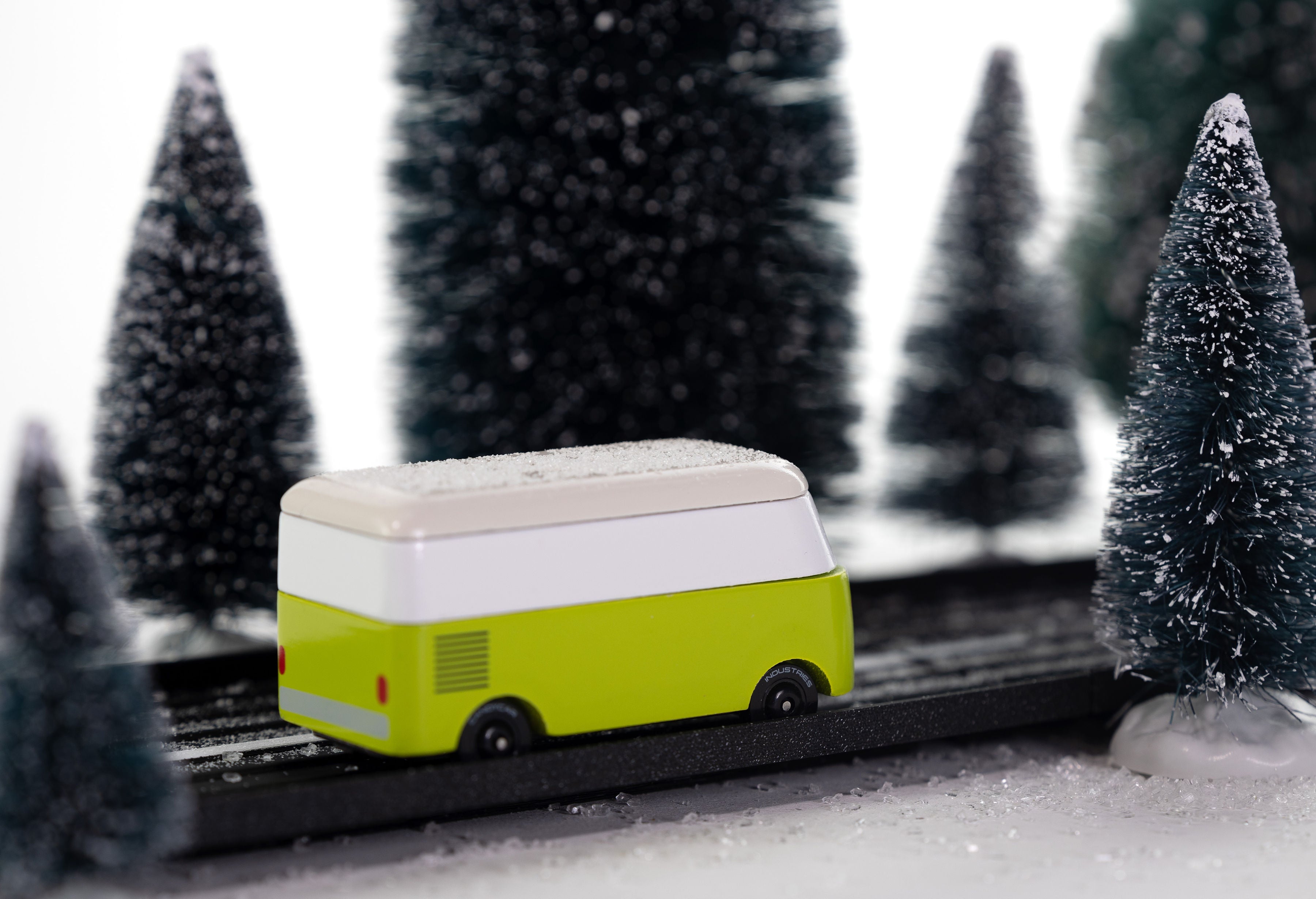 Toy van on a track with snow-covered trees in the background