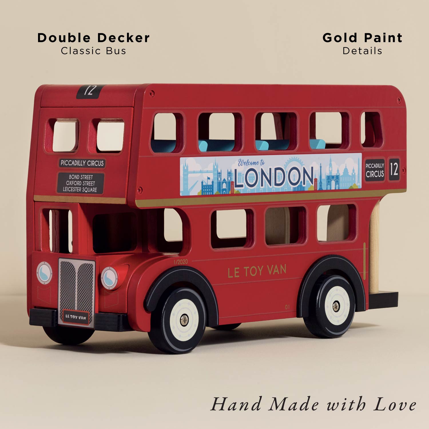 Red double-decker toy bus with gold paint details on a beige background
