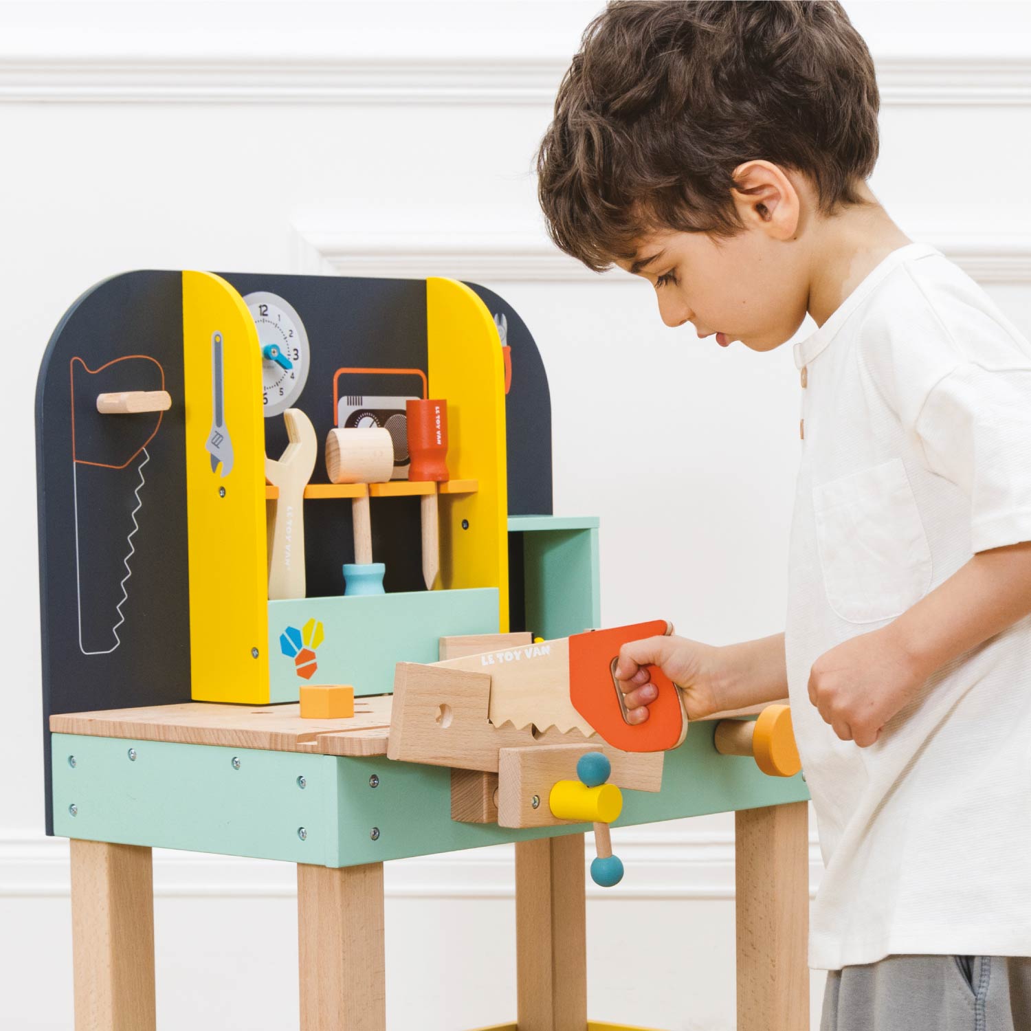 Child playing with a colorful toy workbench