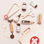 Collection of wooden medical tools and bottles on a light pink background with 'LE TOY VAN' branding.
