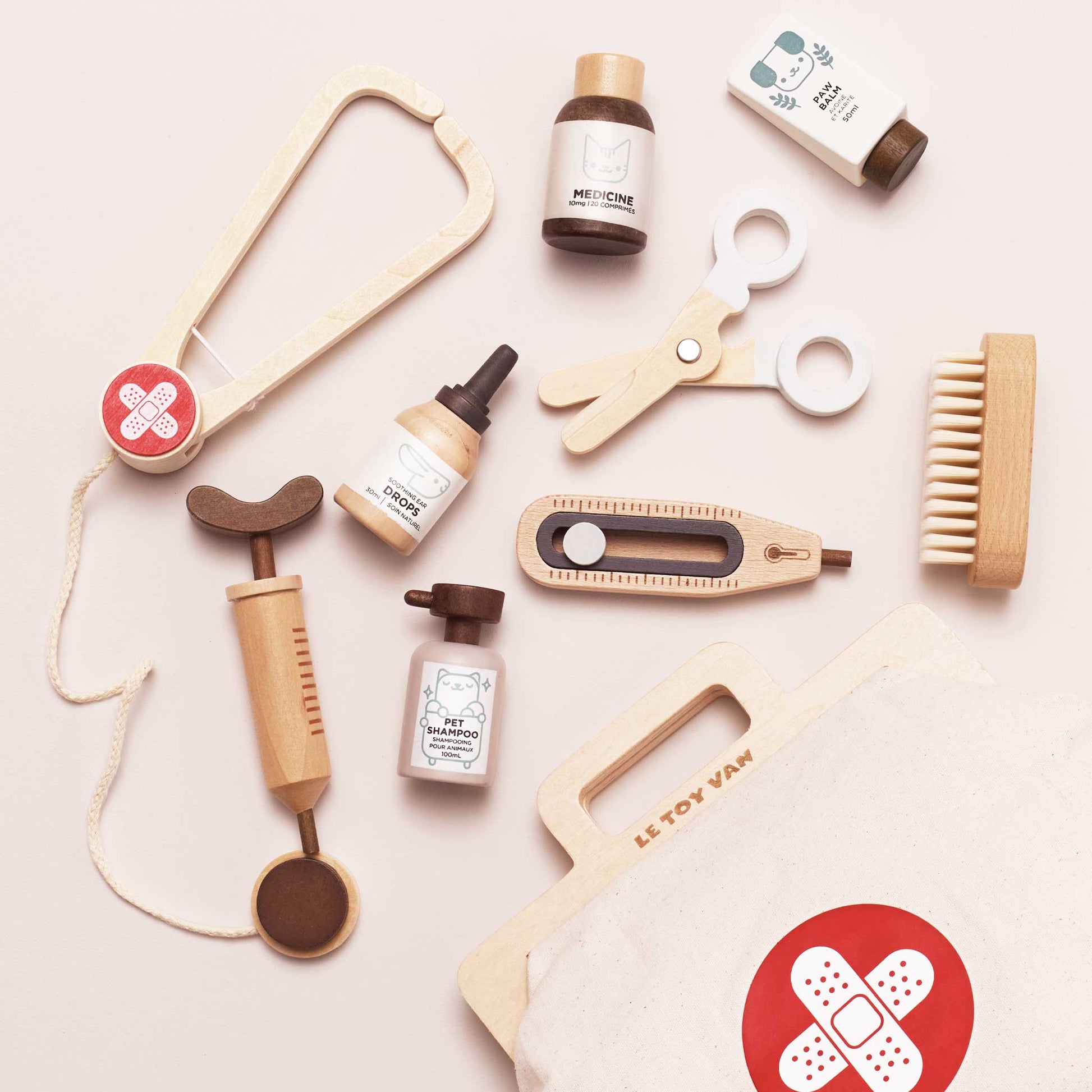 Collection of wooden medical tools and bottles on a light pink background with 'LE TOY VAN' branding.