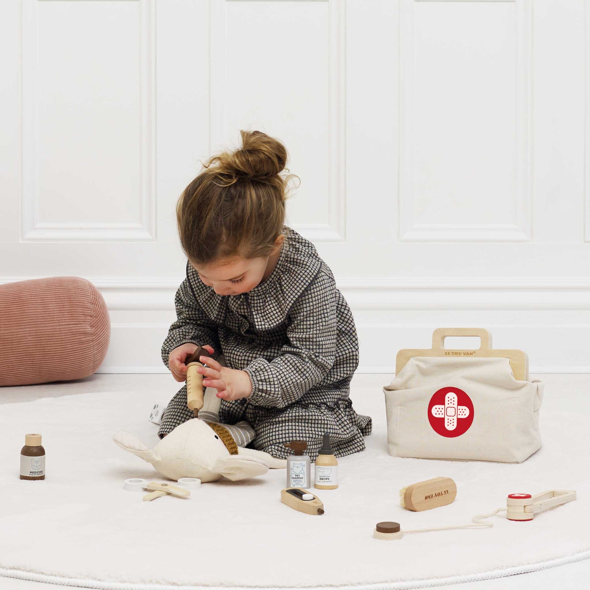 Child playing with toys on a white floor with a white wall background