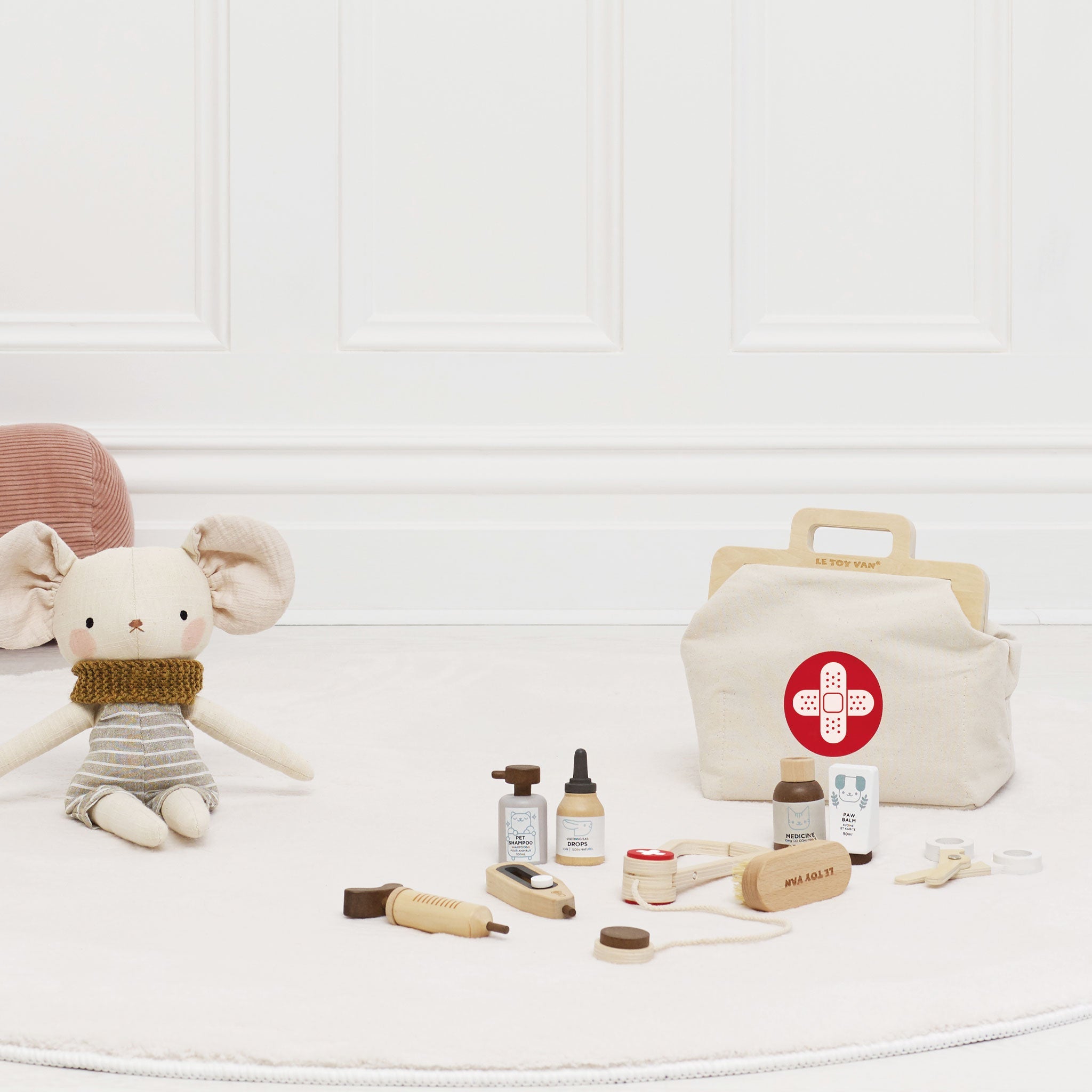 Children's toy set with a bag featuring a red cross symbol on a white surface.