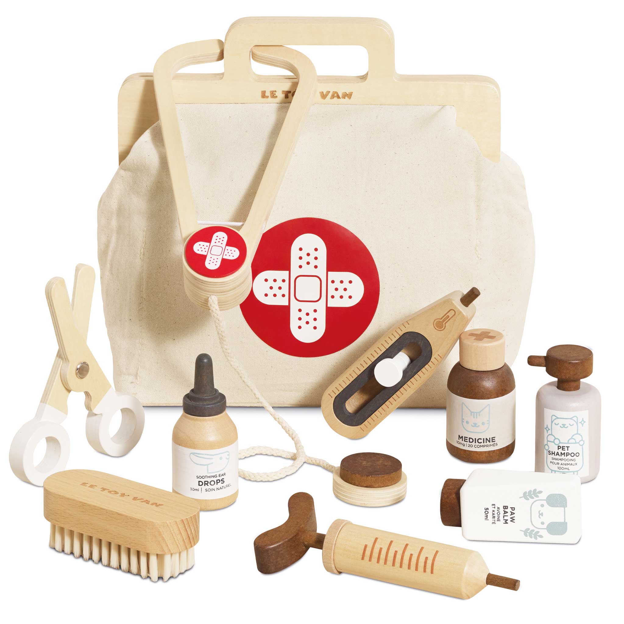 Set of wooden pet grooming tools and a canvas bag with bandage design on a white background
