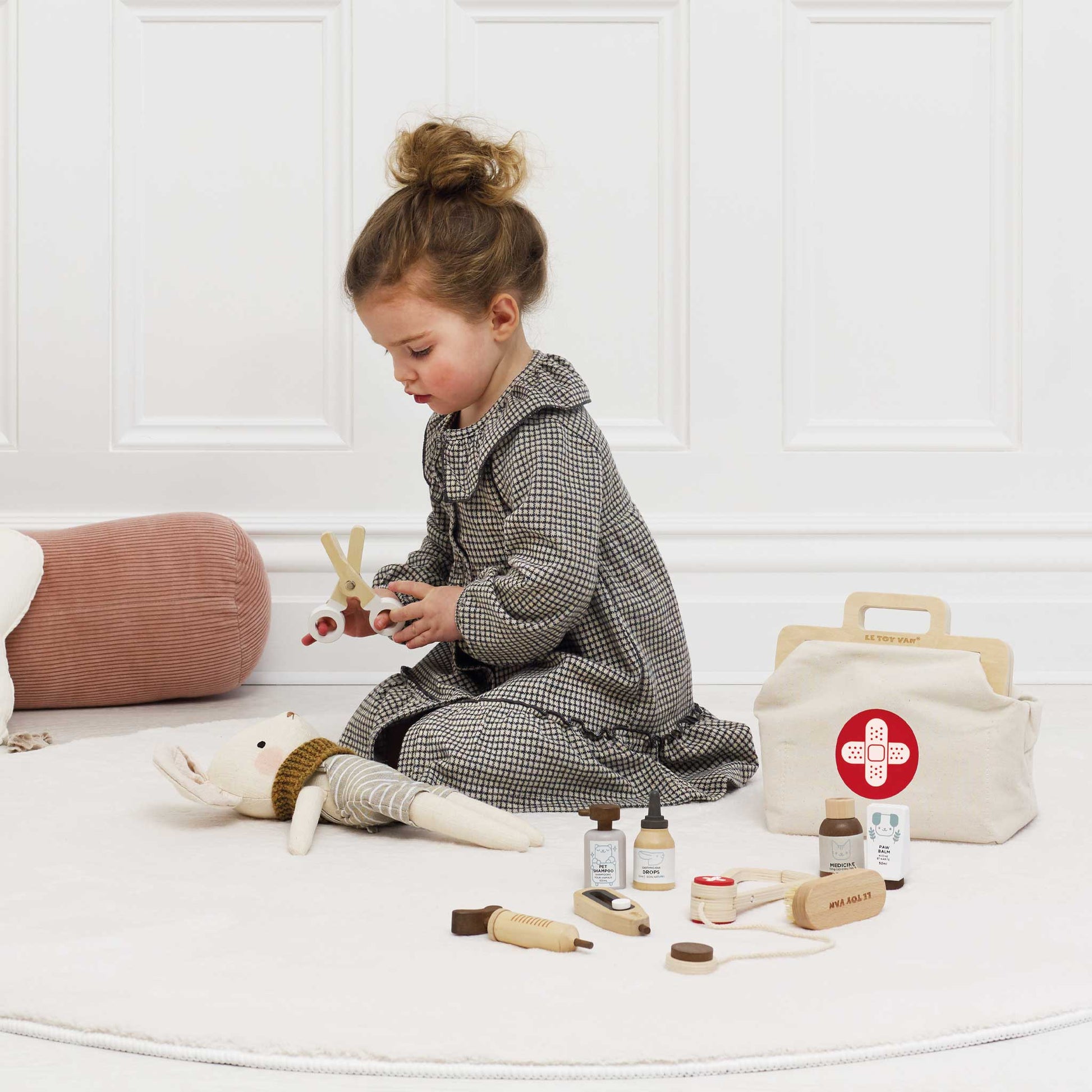 Child playing with toys on a white floor with a white wall background