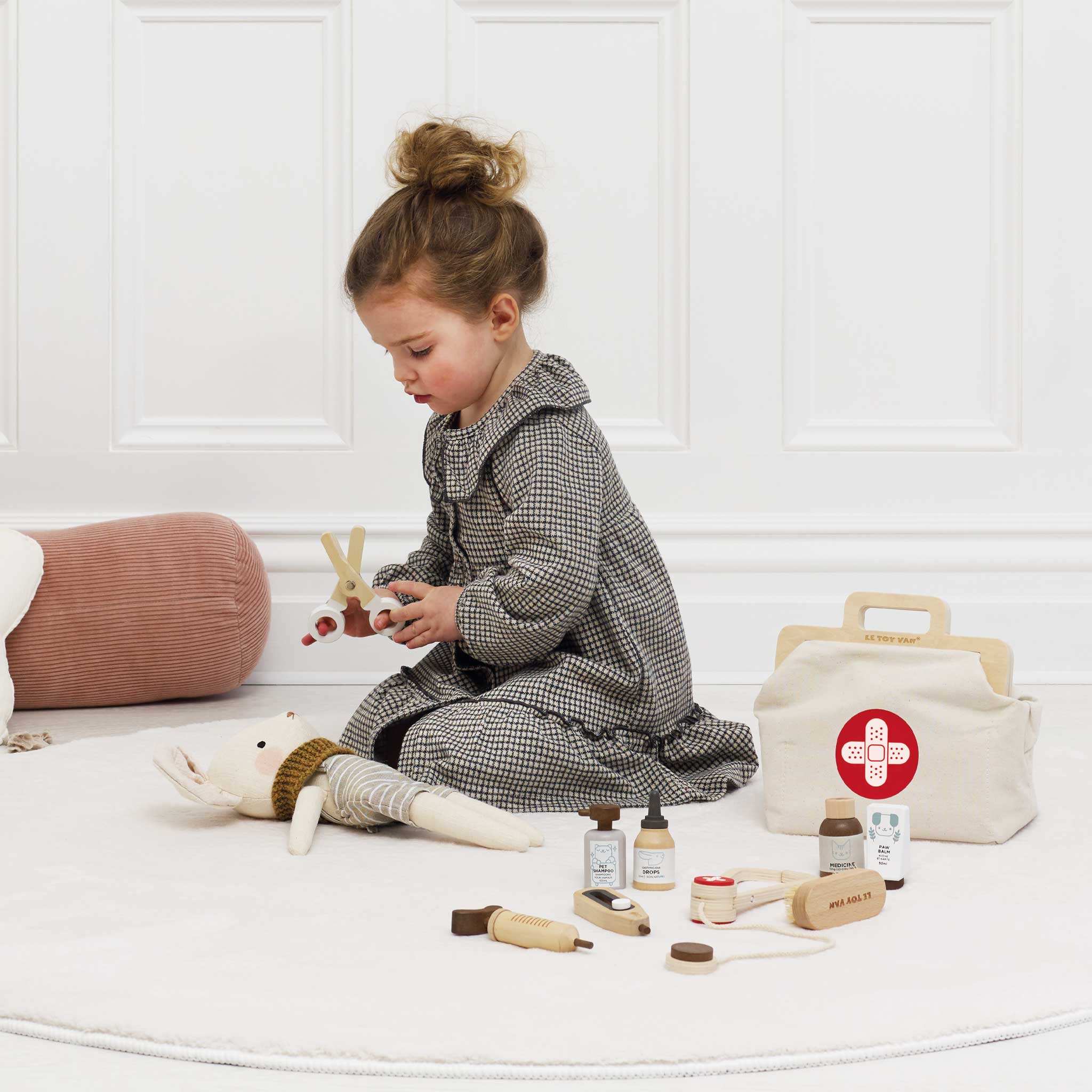 Child playing with toys on a white floor with a white wall background