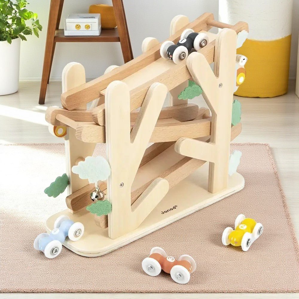 Wooden toy track with cars on a beige rug in a room setting