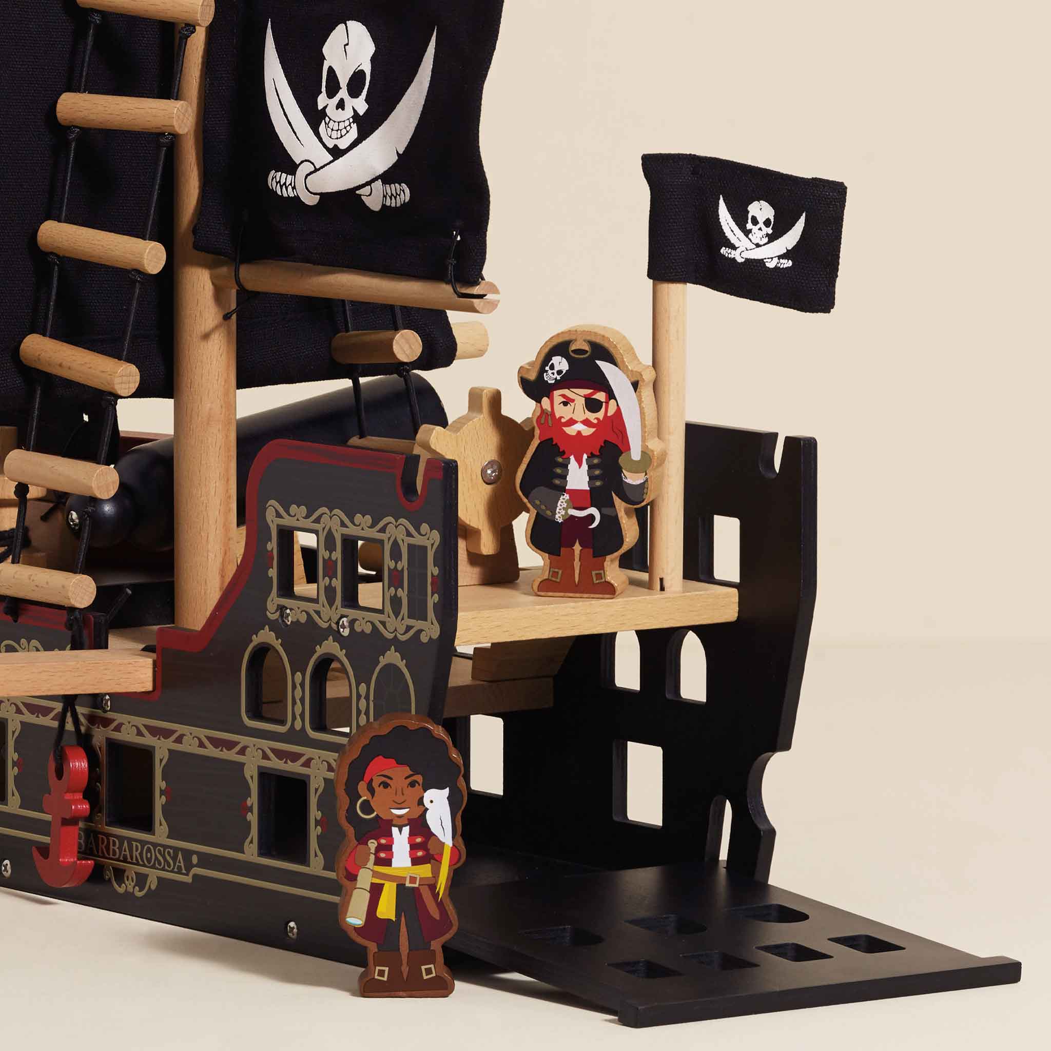 Pirate ship toy with figures and flags on a beige background