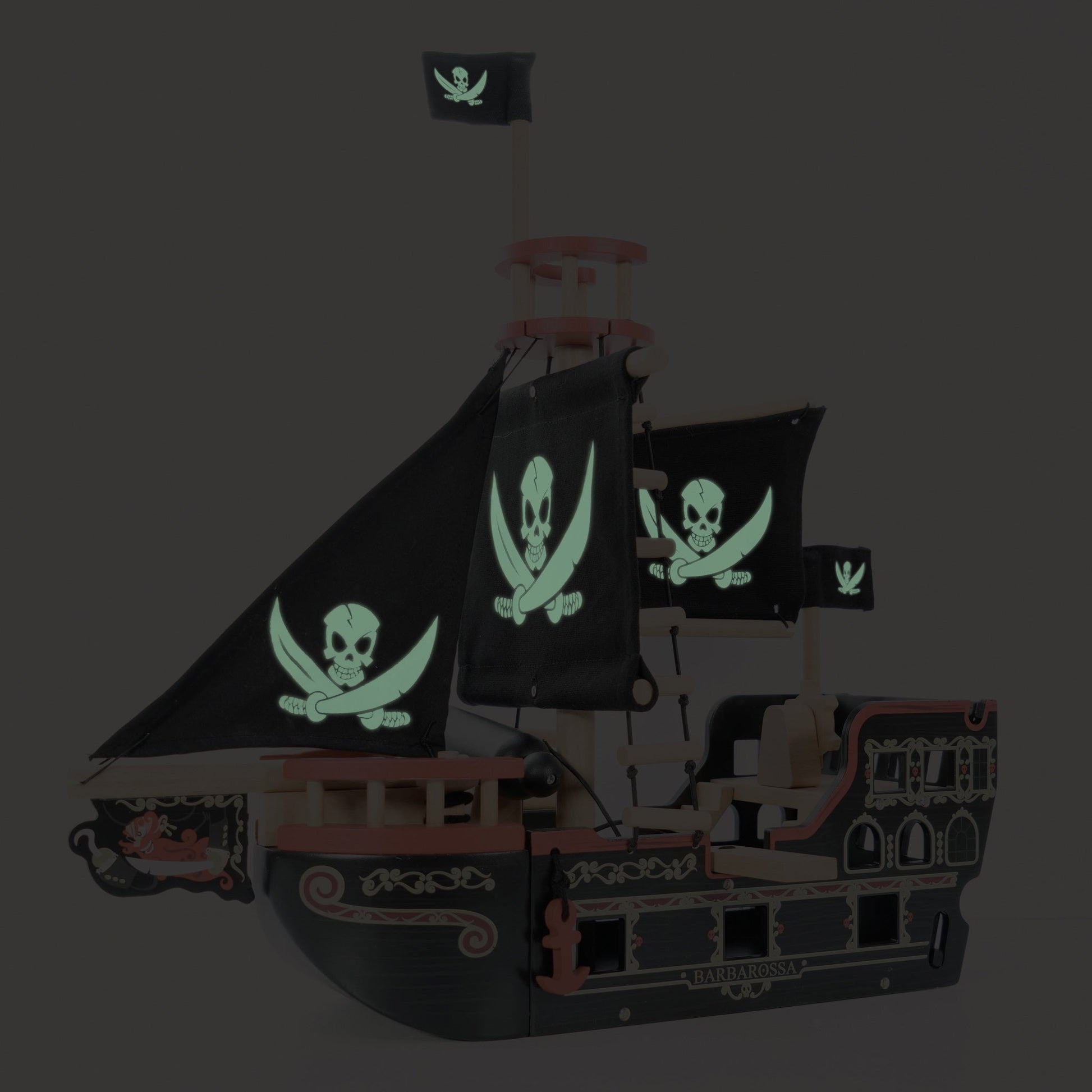 Pirate ship model with glowing skull and crossbones flags on a dark background