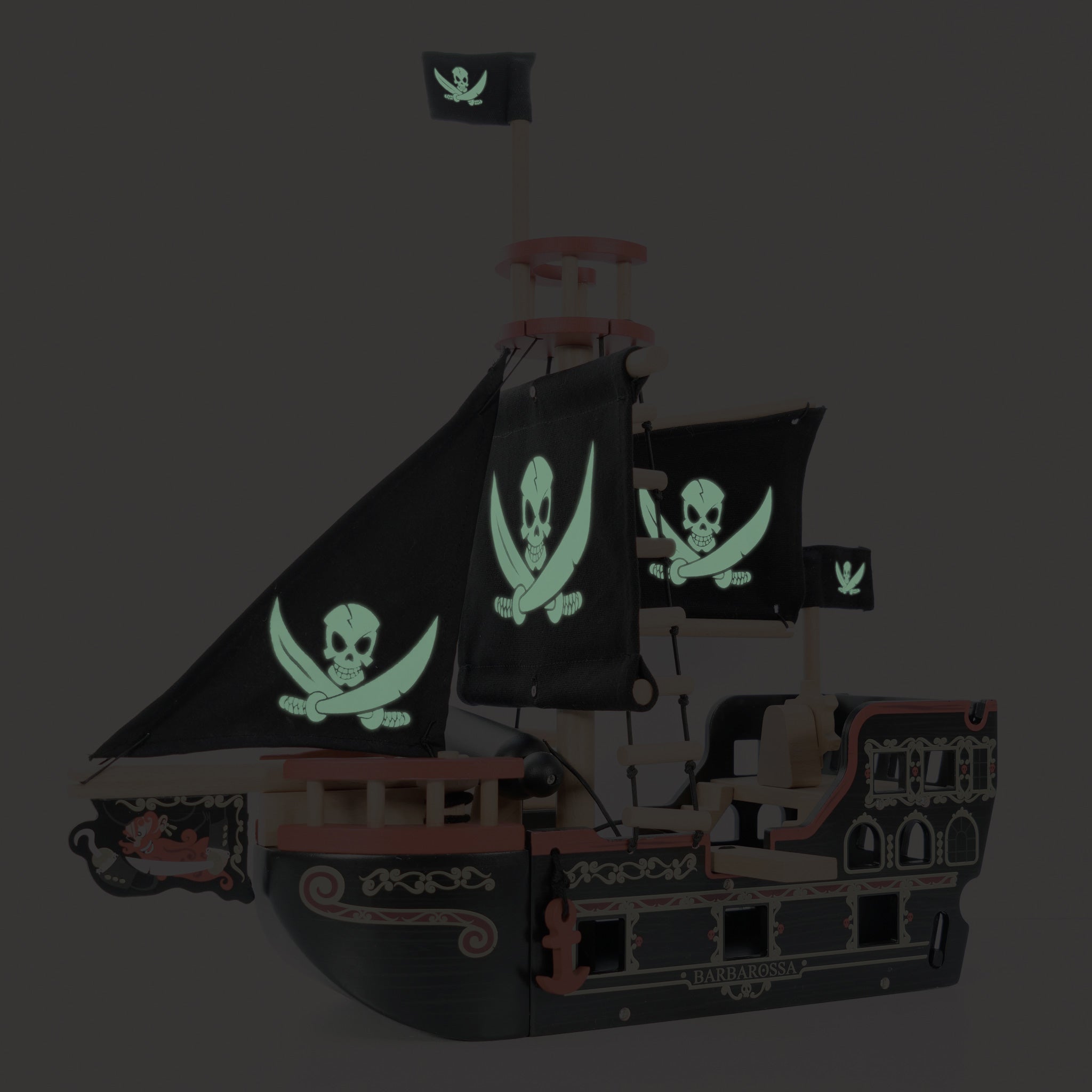 Pirate ship model with glowing skull and crossbones flags on a dark background