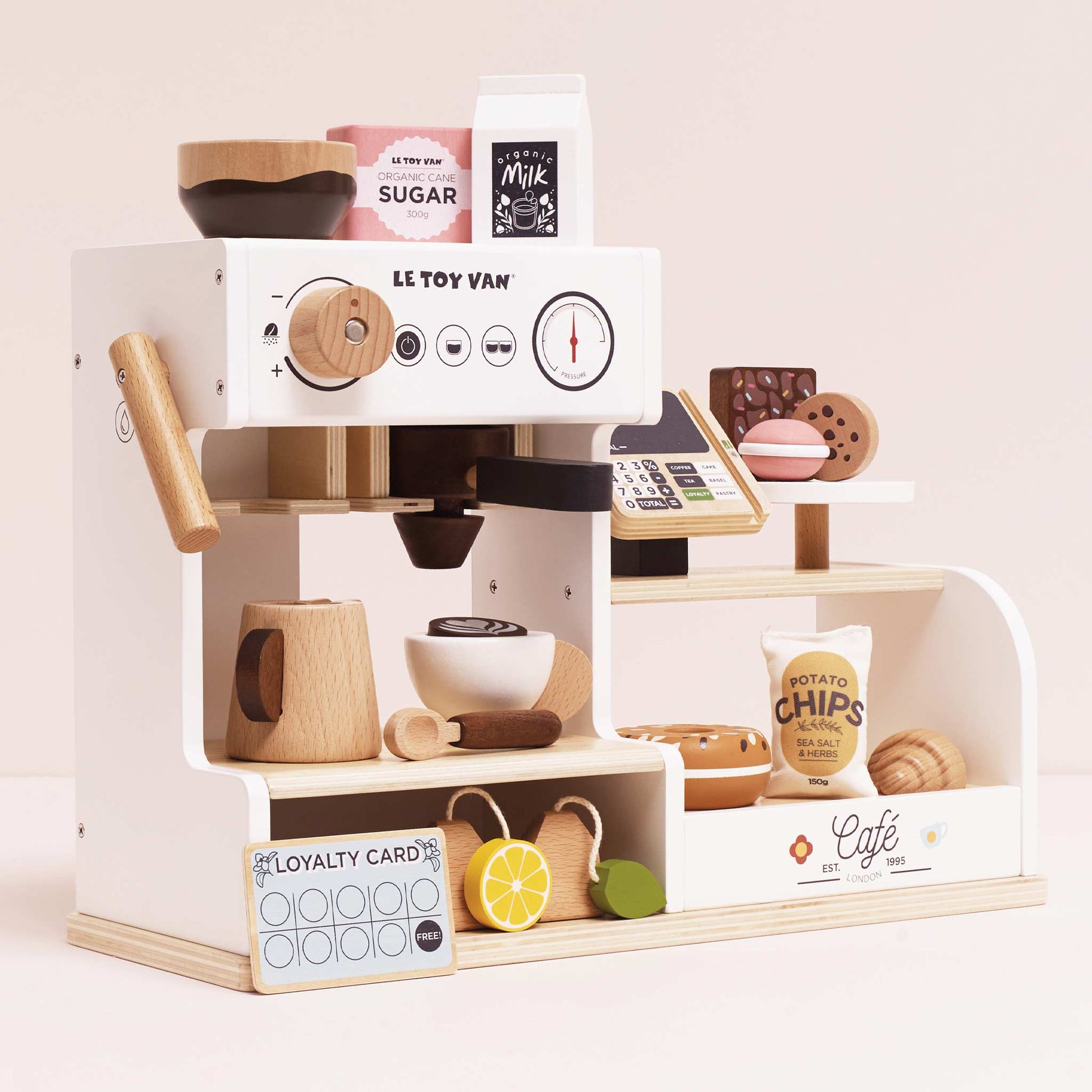 Toy coffee machine set with various accessories on a light pink background, featuring 'Le Toy Van' branding.