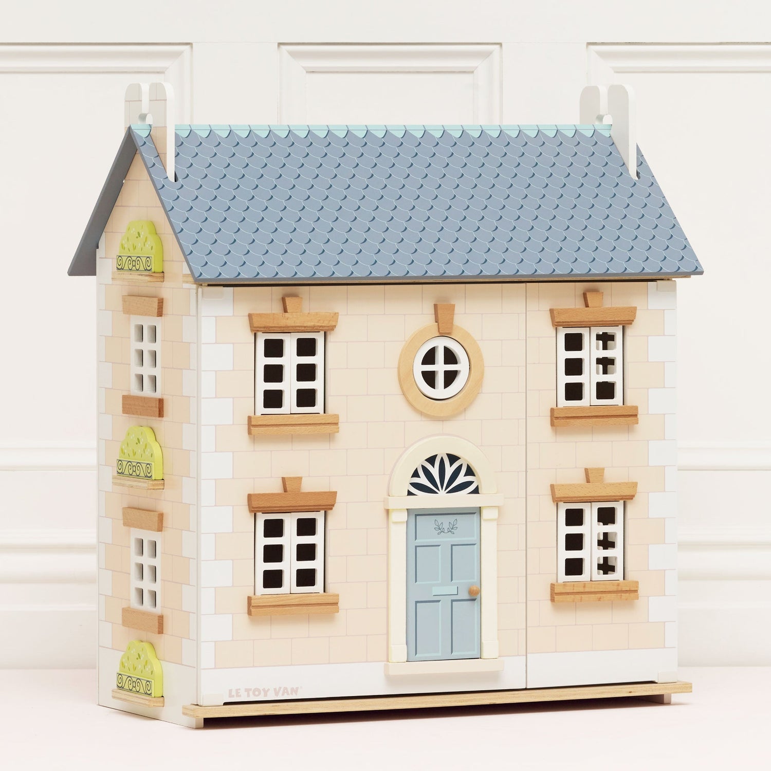 Toy house model with a light blue roof and door on a white background