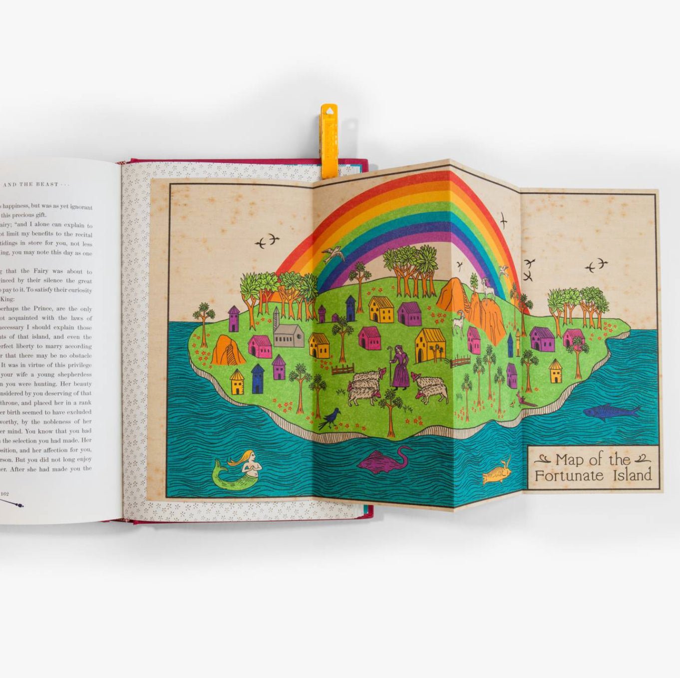 Open book with a colorful illustration of an island and rainbow on a white background
