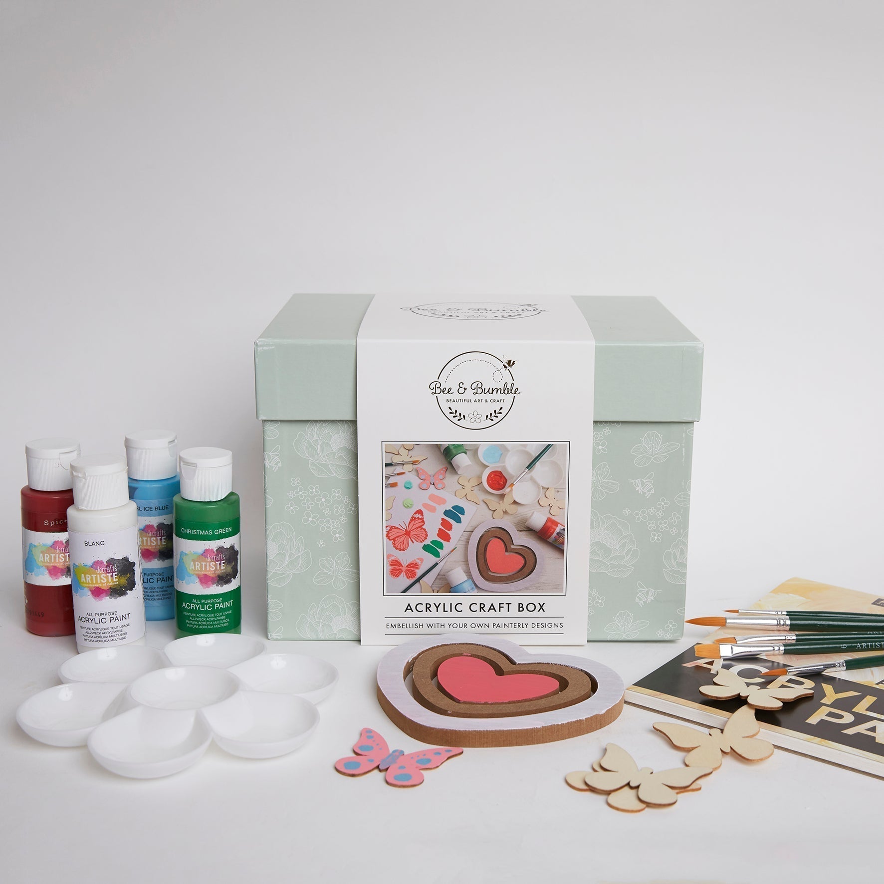 Acrylic craft box with paint bottles, brushes, and craft materials on a white background
