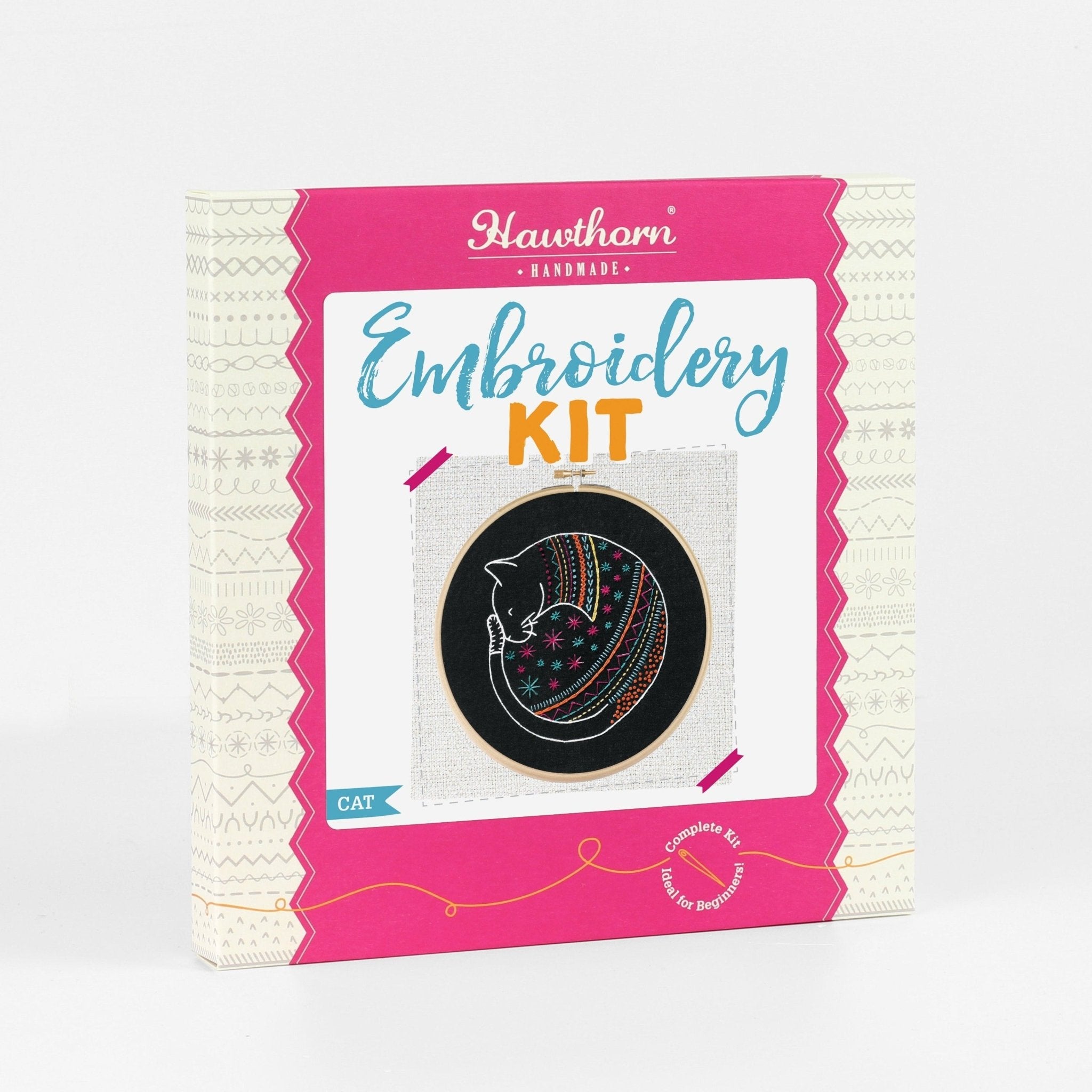 Embroidery kit packaging with pink border and cat design on a white background