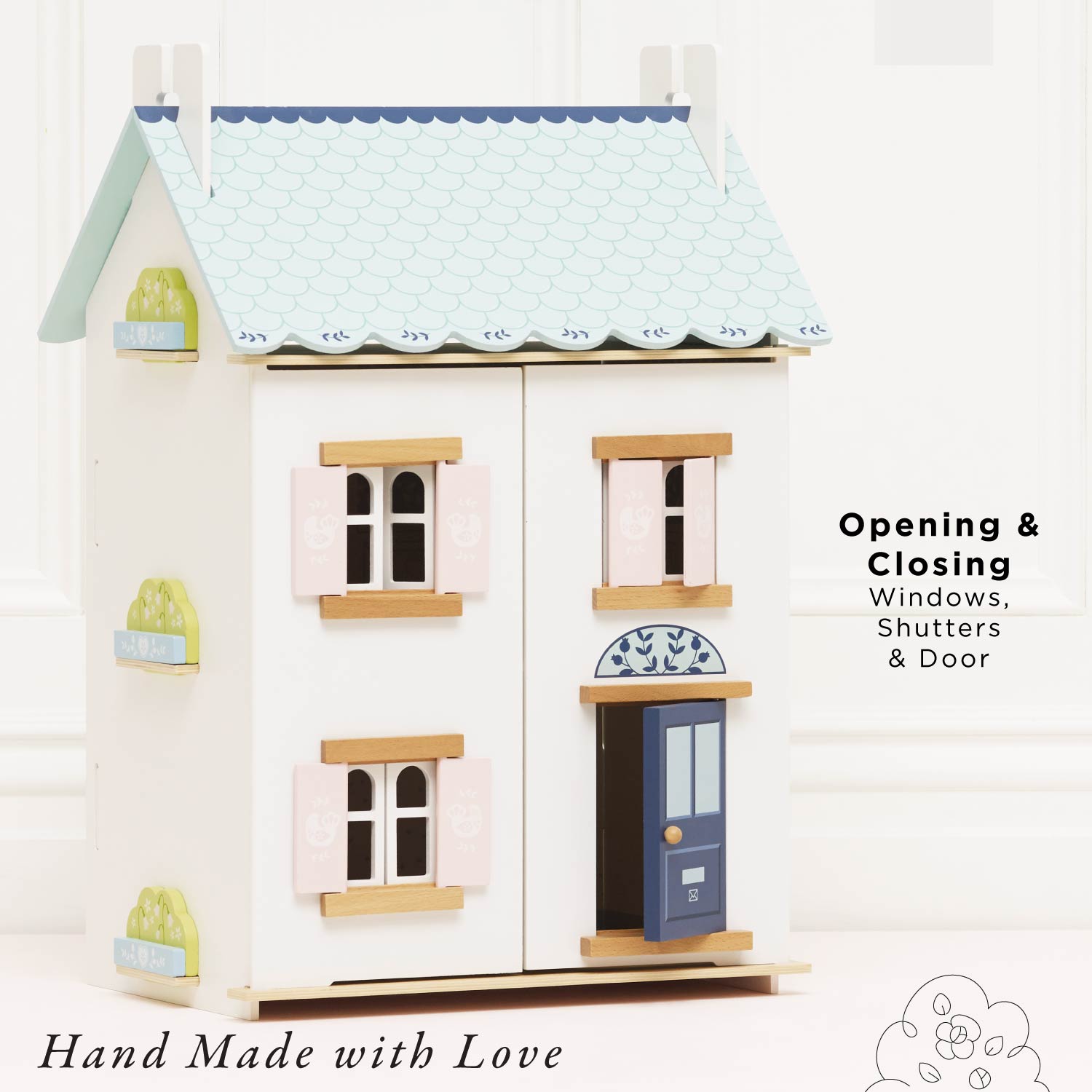 Toy dollhouse with opening windows, shutters, and door on a white background