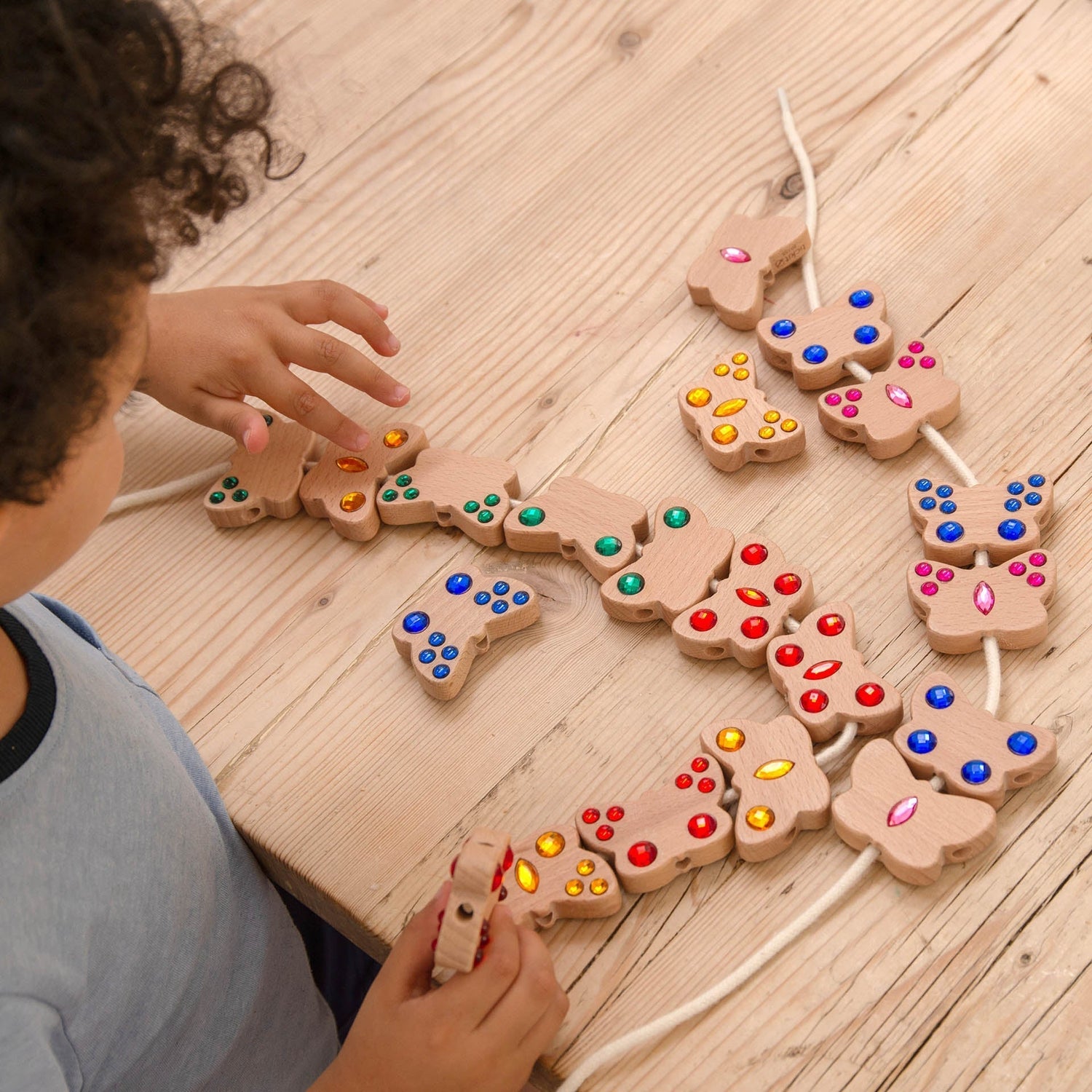 Child playing with a wooden puzzle on a wooden floor