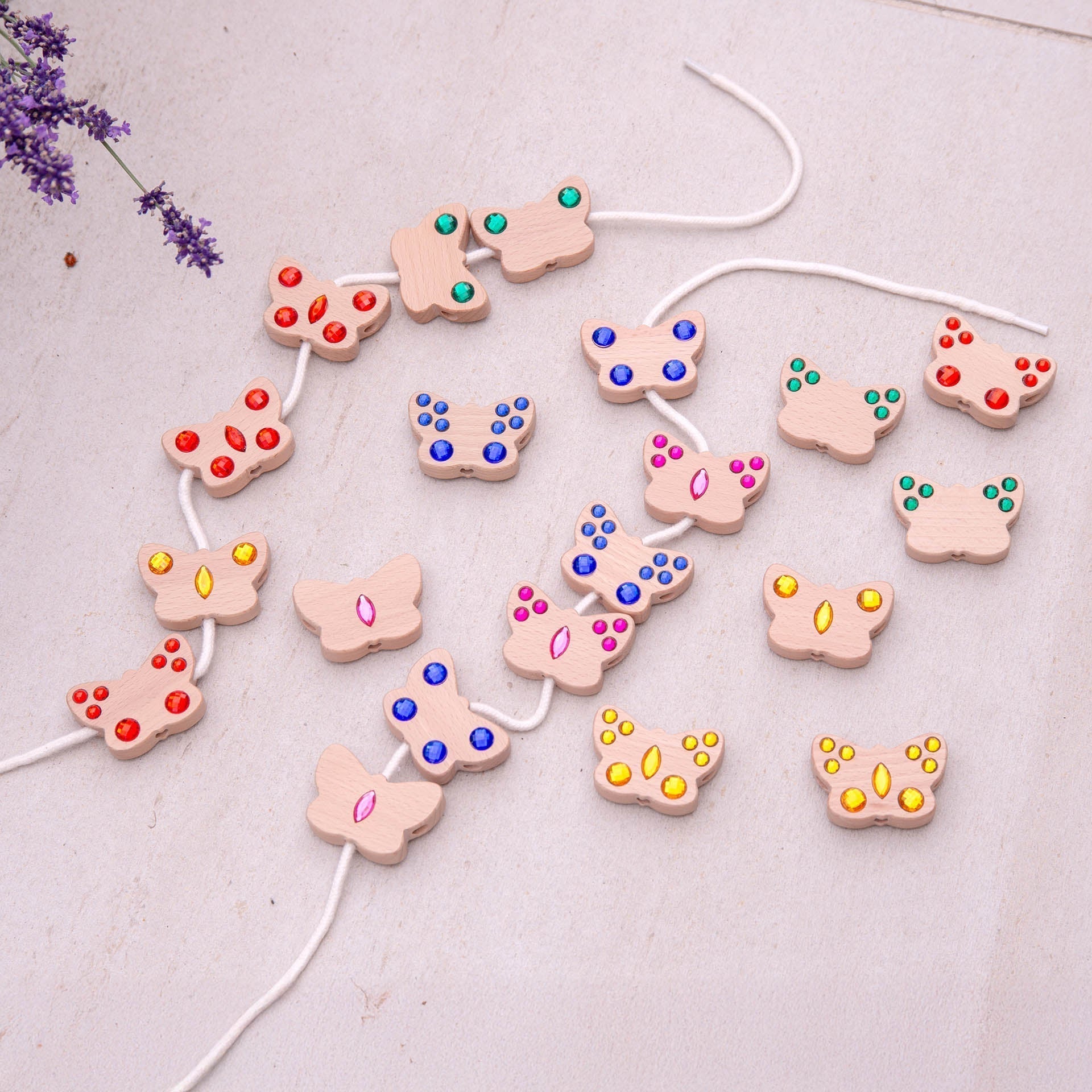 Butterfly-shaped beads with colorful centers on a white string against a light background.