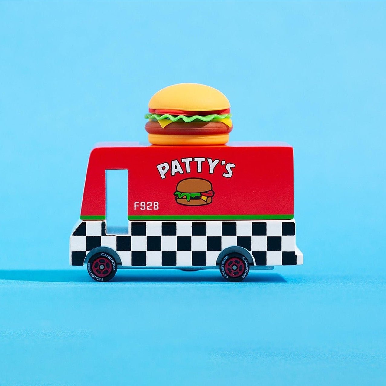 Toy food truck with a burger on top against a blue background