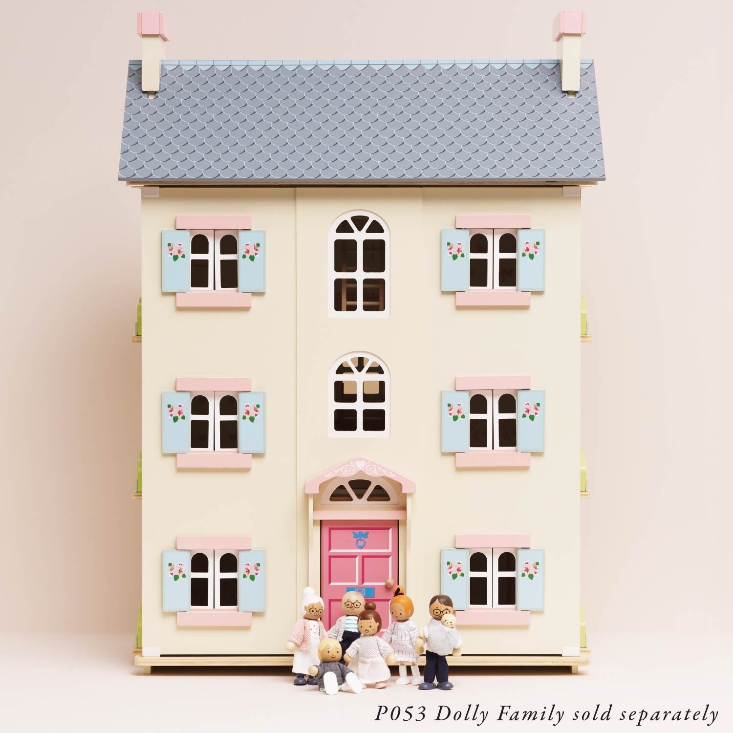 Small model of a two-story house with a pink door and multiple windows on a light pink background.