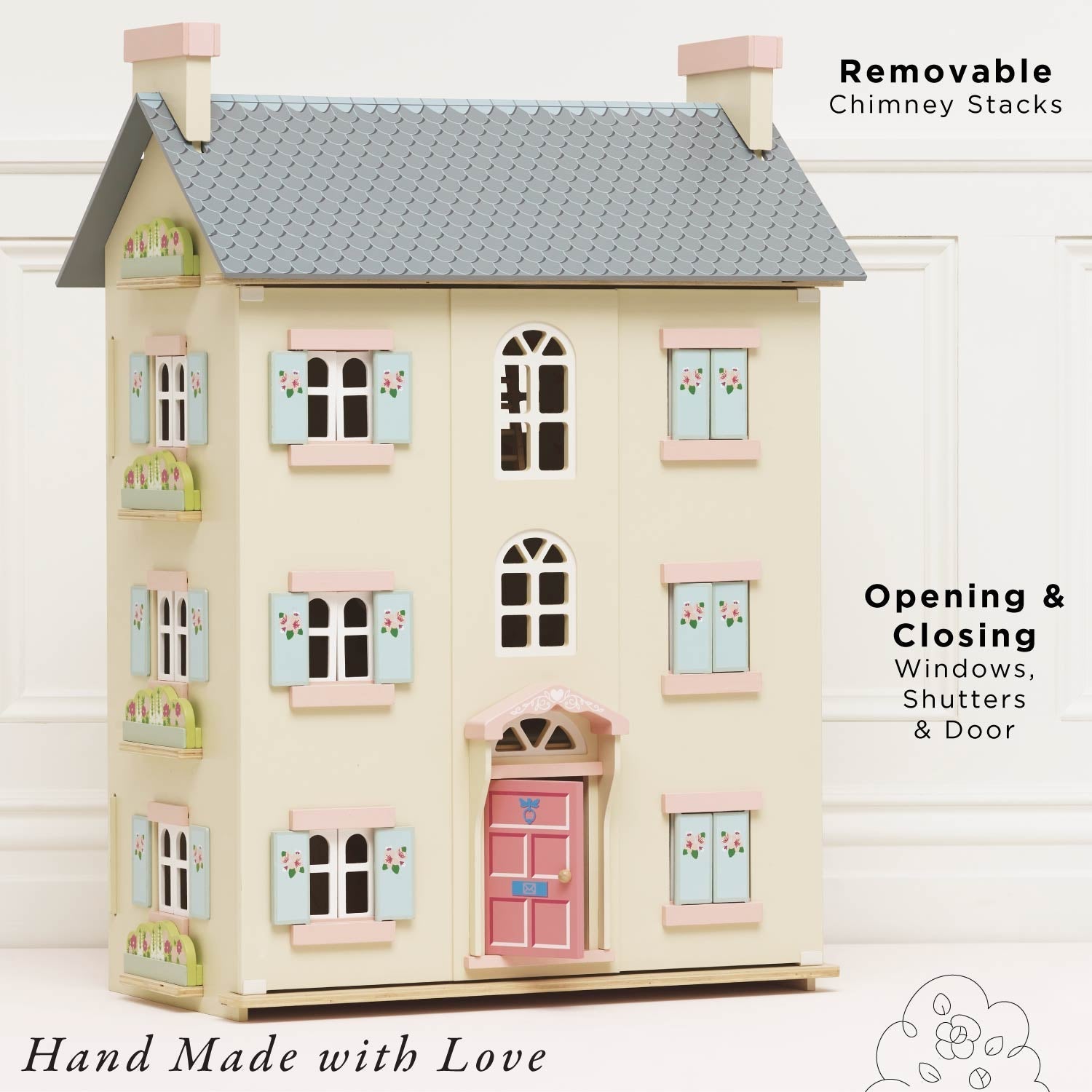 Toy dollhouse with removable chimney stacks, opening windows, and a pink door on a white background.