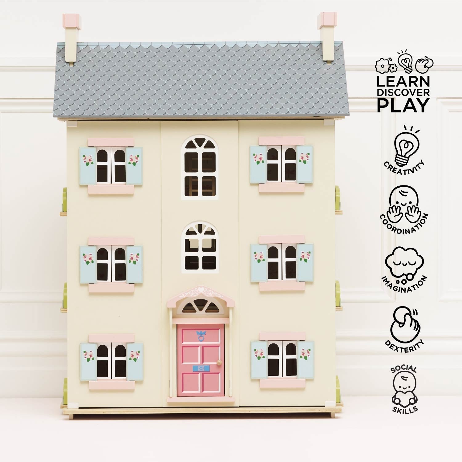 Toy dollhouse with pastel colors on a white background, featuring the 'Learn Discover Play' logo.