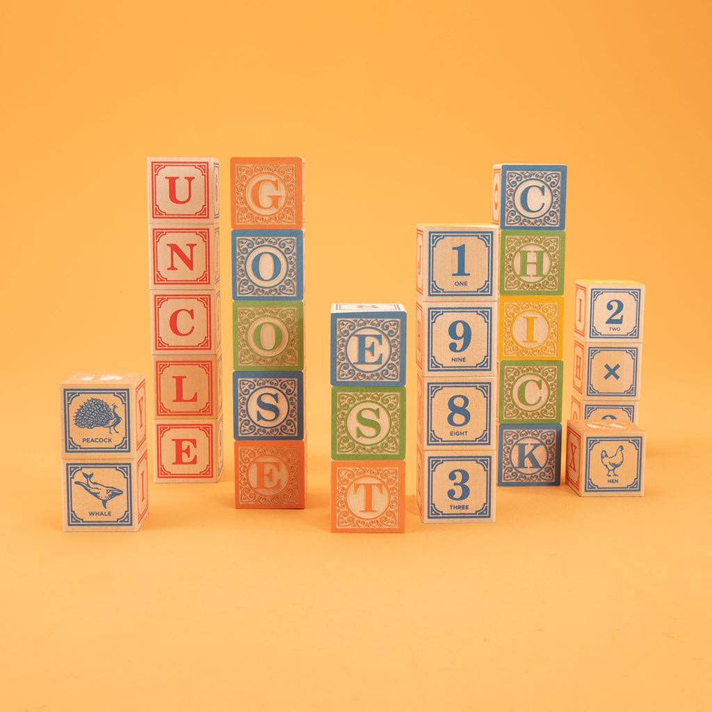 Stack of colorful alphabet blocks on a yellow background