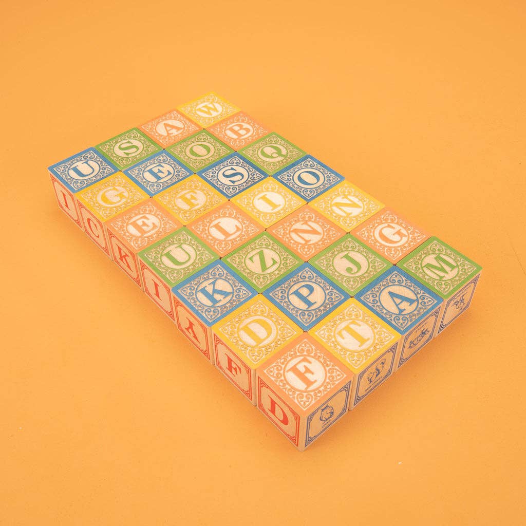 Stack of colorful alphabet blocks on an orange background