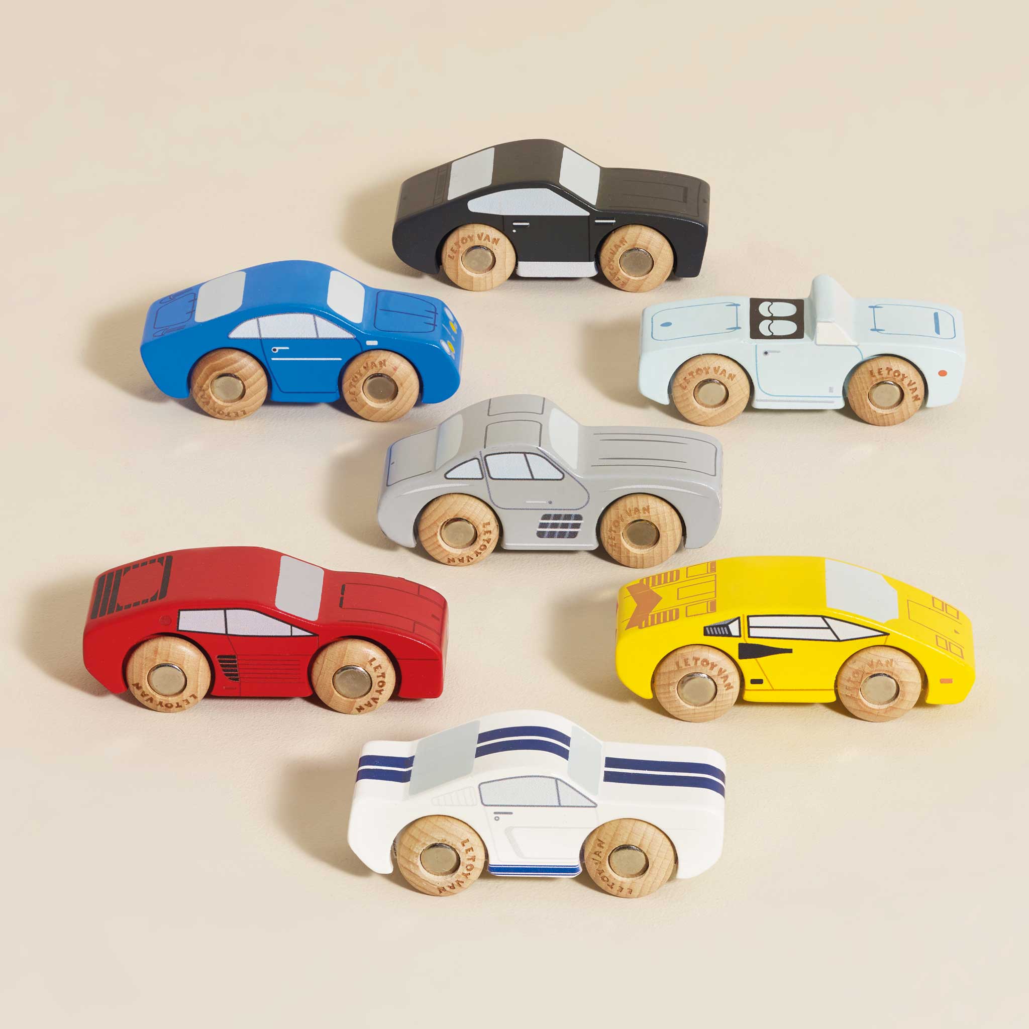 Set of colorful wooden toy cars on a beige background