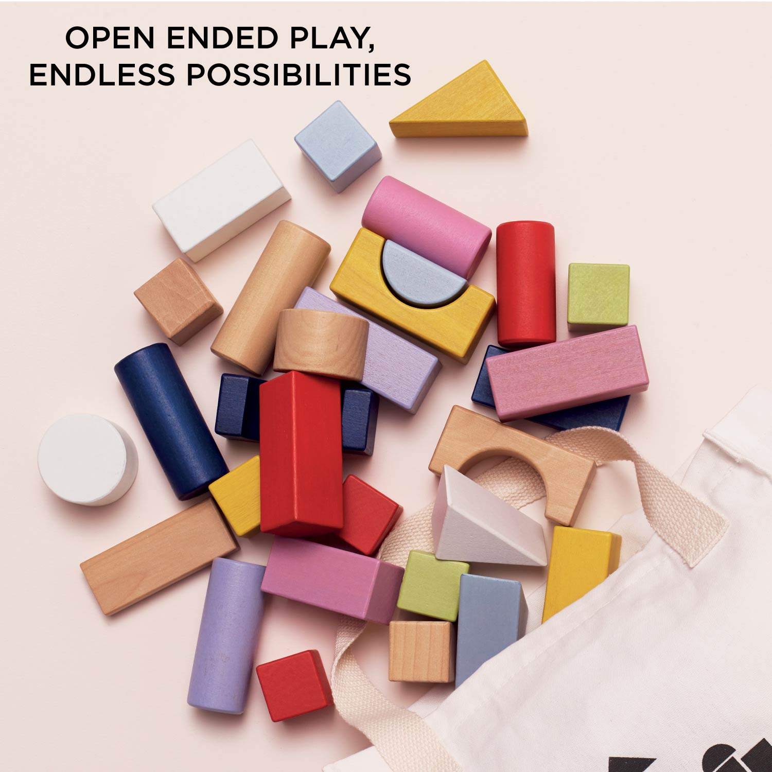 Colorful wooden blocks with text 'Open Ended Play, Endless Possibilities' on a light pink background