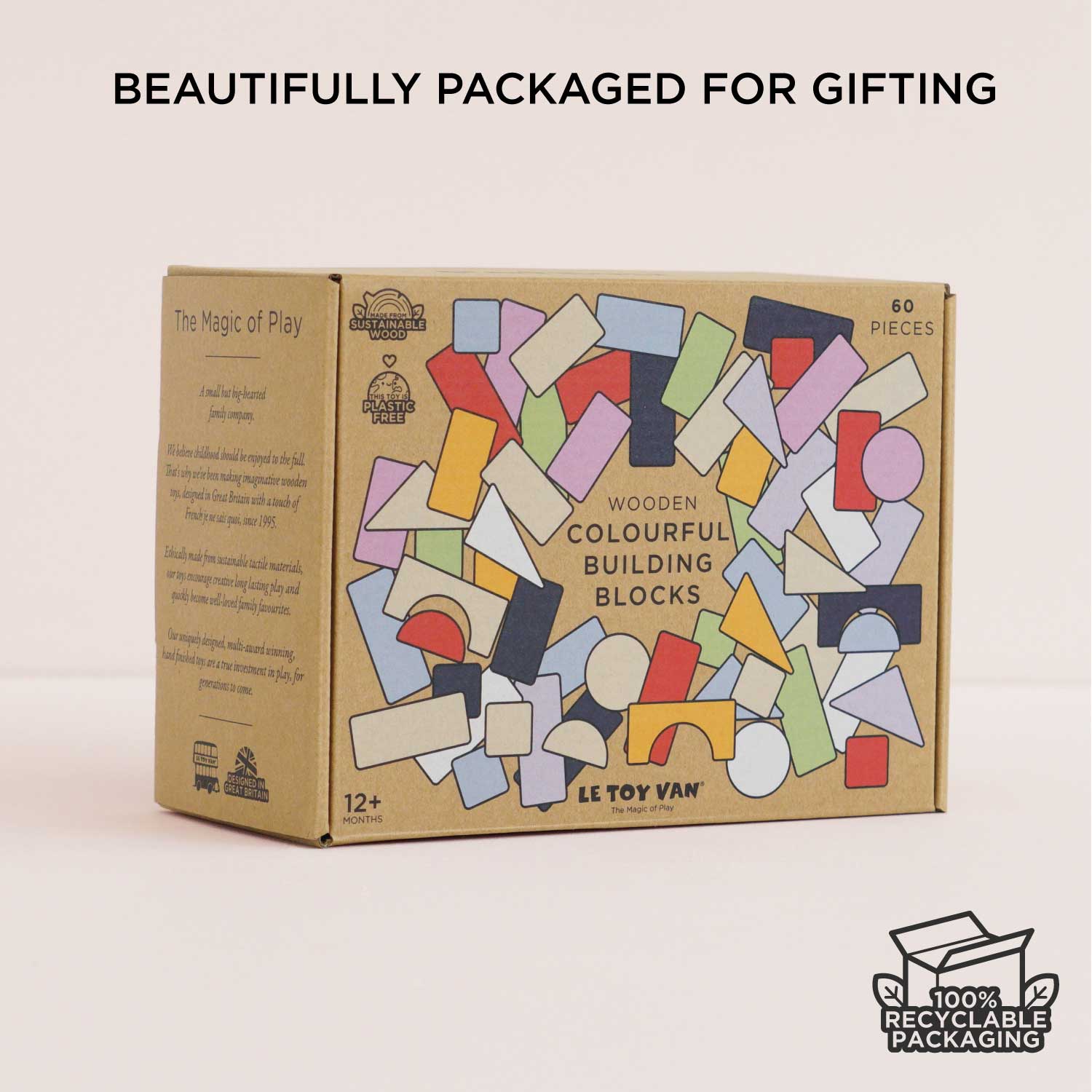 Box of wooden building blocks with colorful shapes on a beige background, featuring Le Toy Van branding.