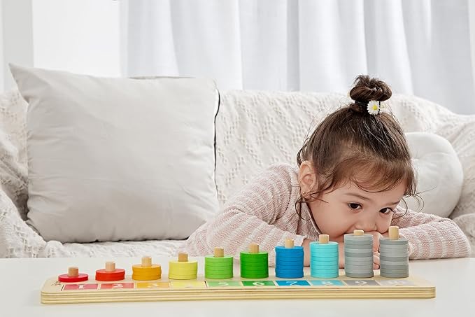 Child playing with a colorful wooden educational toy on a white couch.