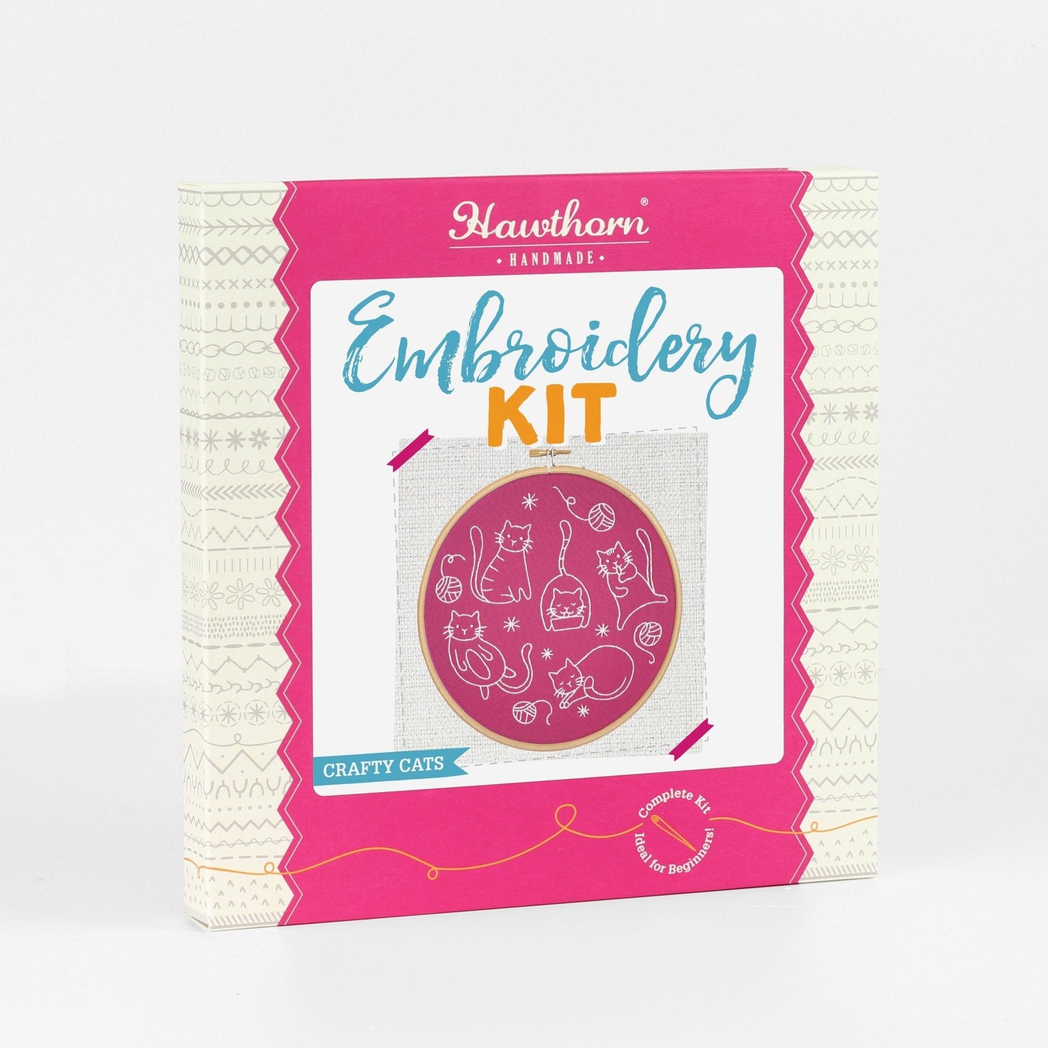 Embroidery kit packaging with pink border and cat-themed design on a white background