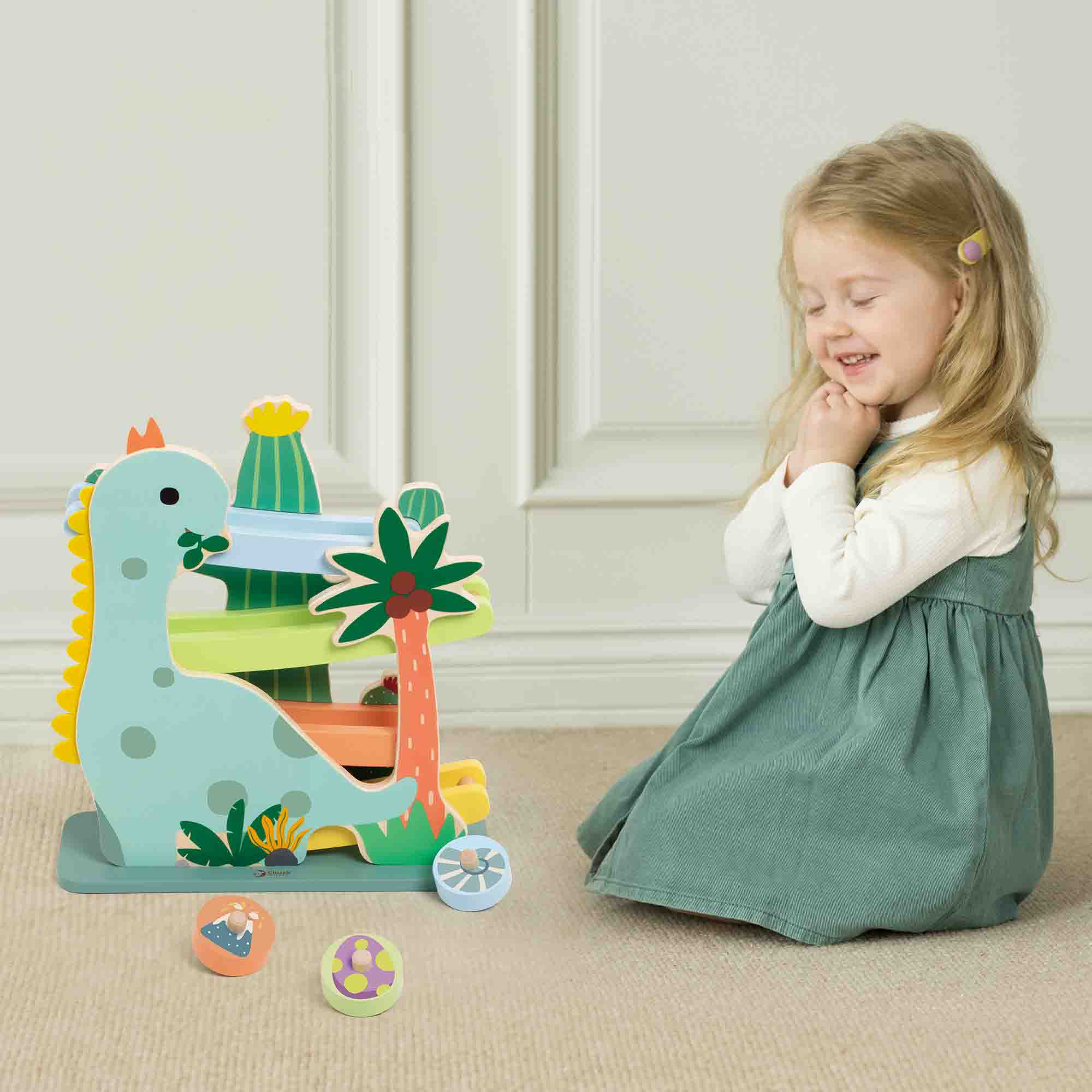 Child playing with a dinosaur toy set on a beige carpet.
