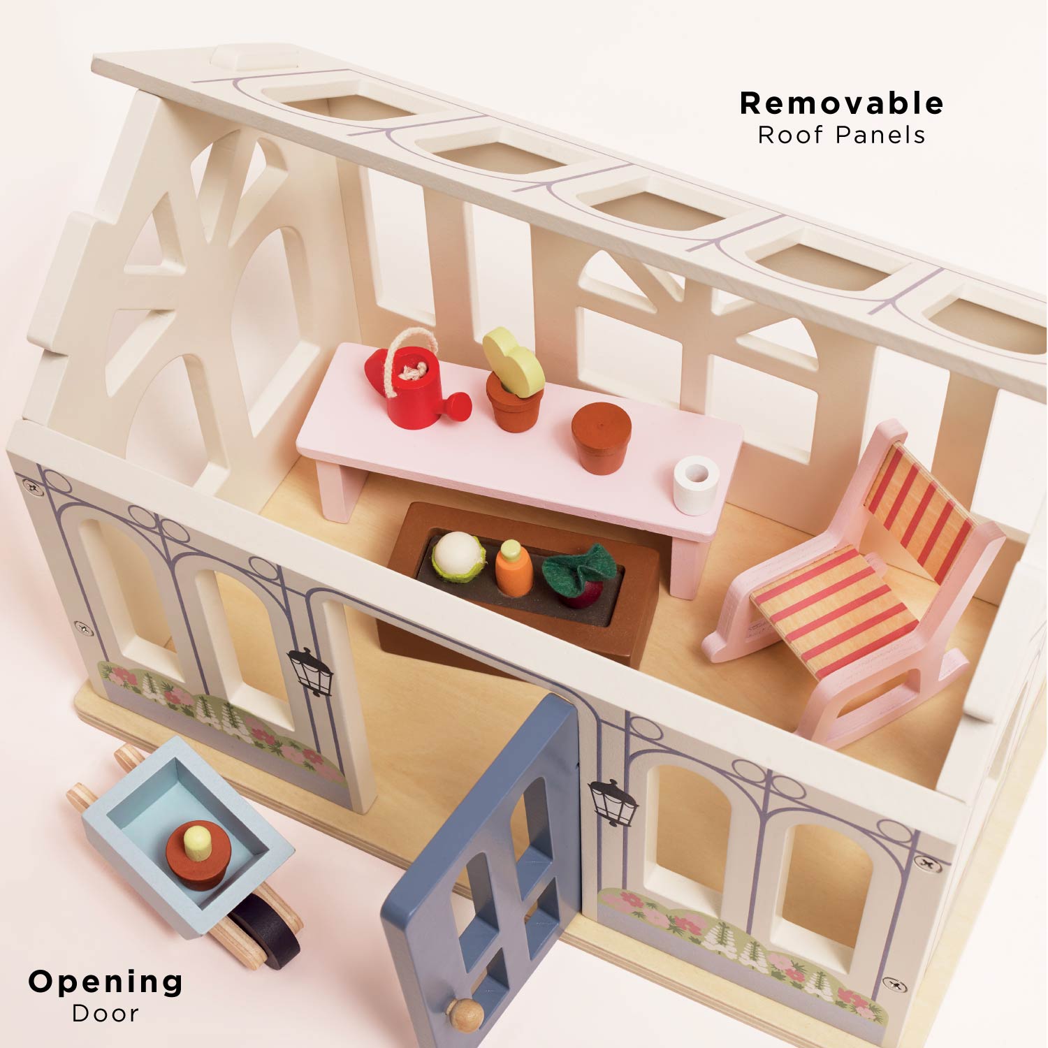 Wooden dollhouse with removable roof panels and furniture on a pink background