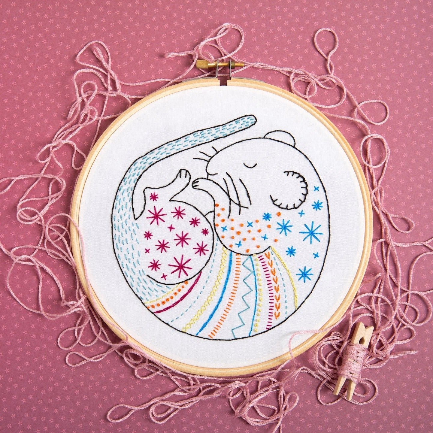 Embroidery hoop with a colorful elephant design on a pink background