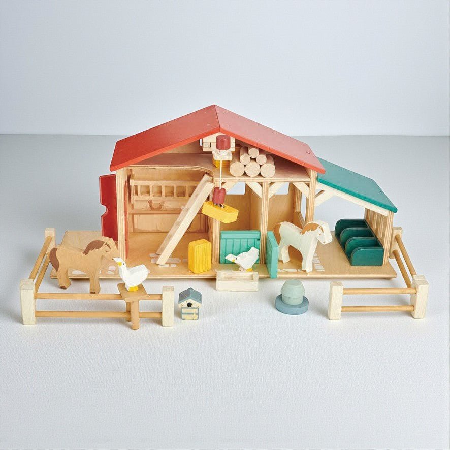 Toy farm set with barn, animals, and accessories on a light gray background