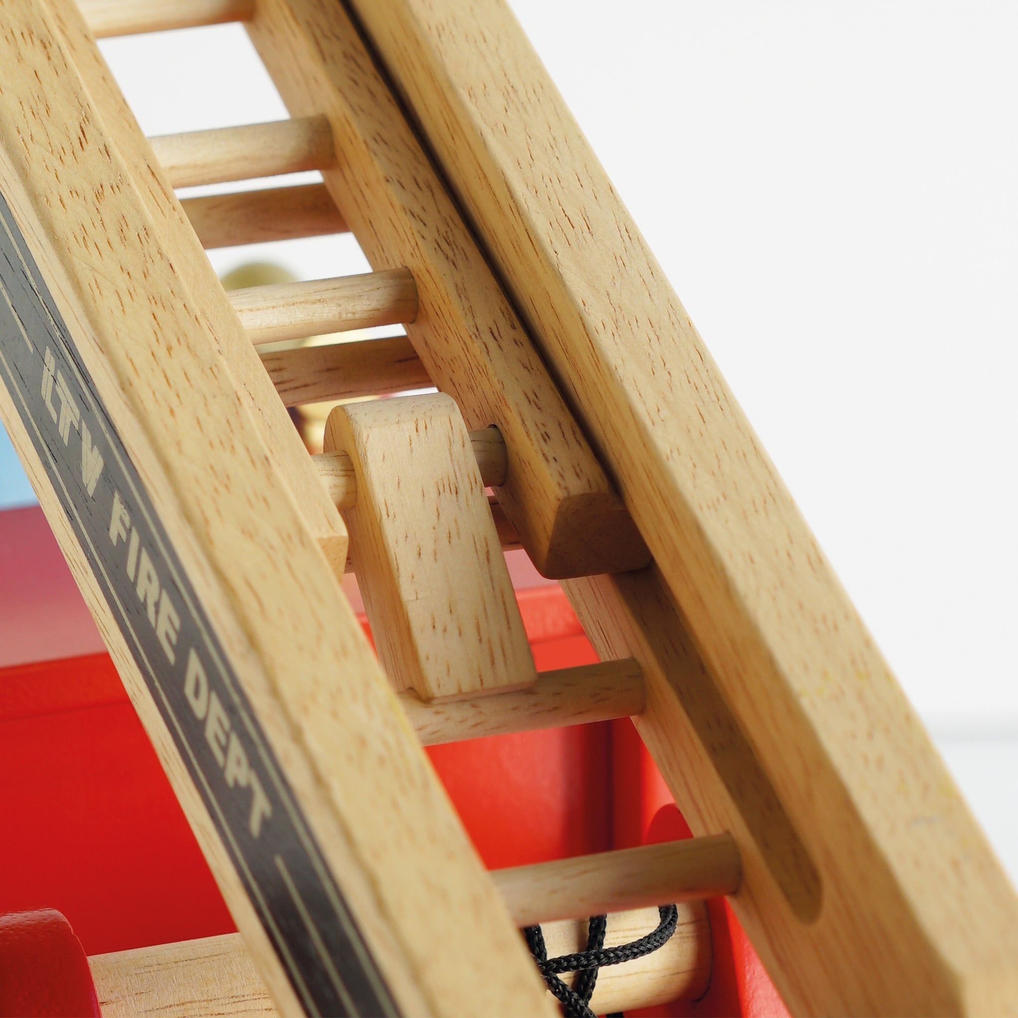 Close-up of a wooden fire department ladder with 'FIRE DEPT' label.