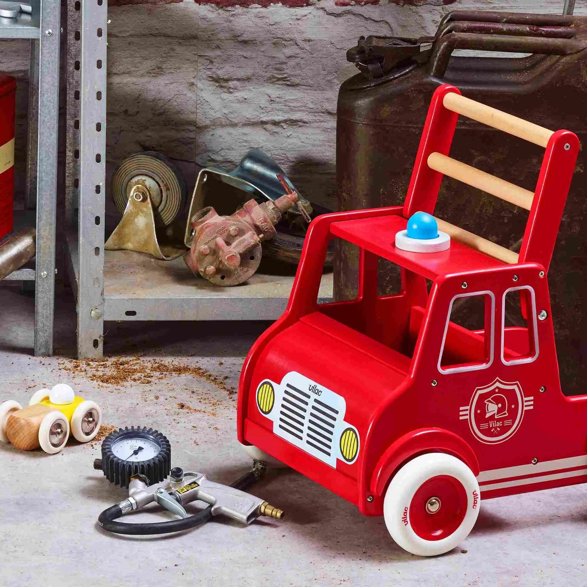 Red toy fire truck with tools on a workshop floor