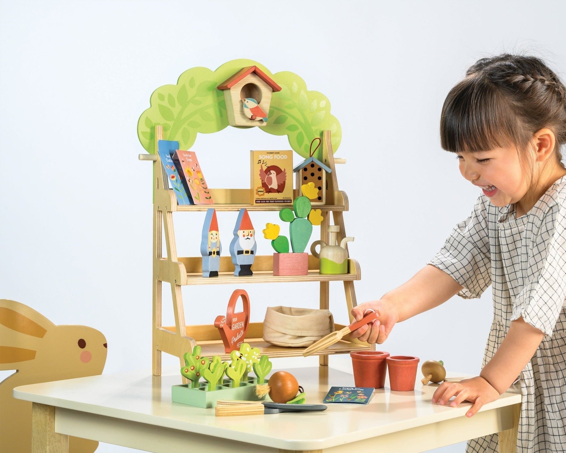 Child playing with a toy garden set on a table