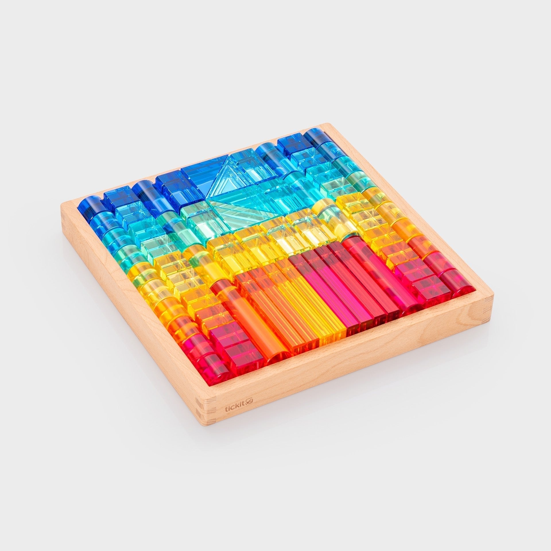 Colorful transparent blocks on a wooden base with a white background